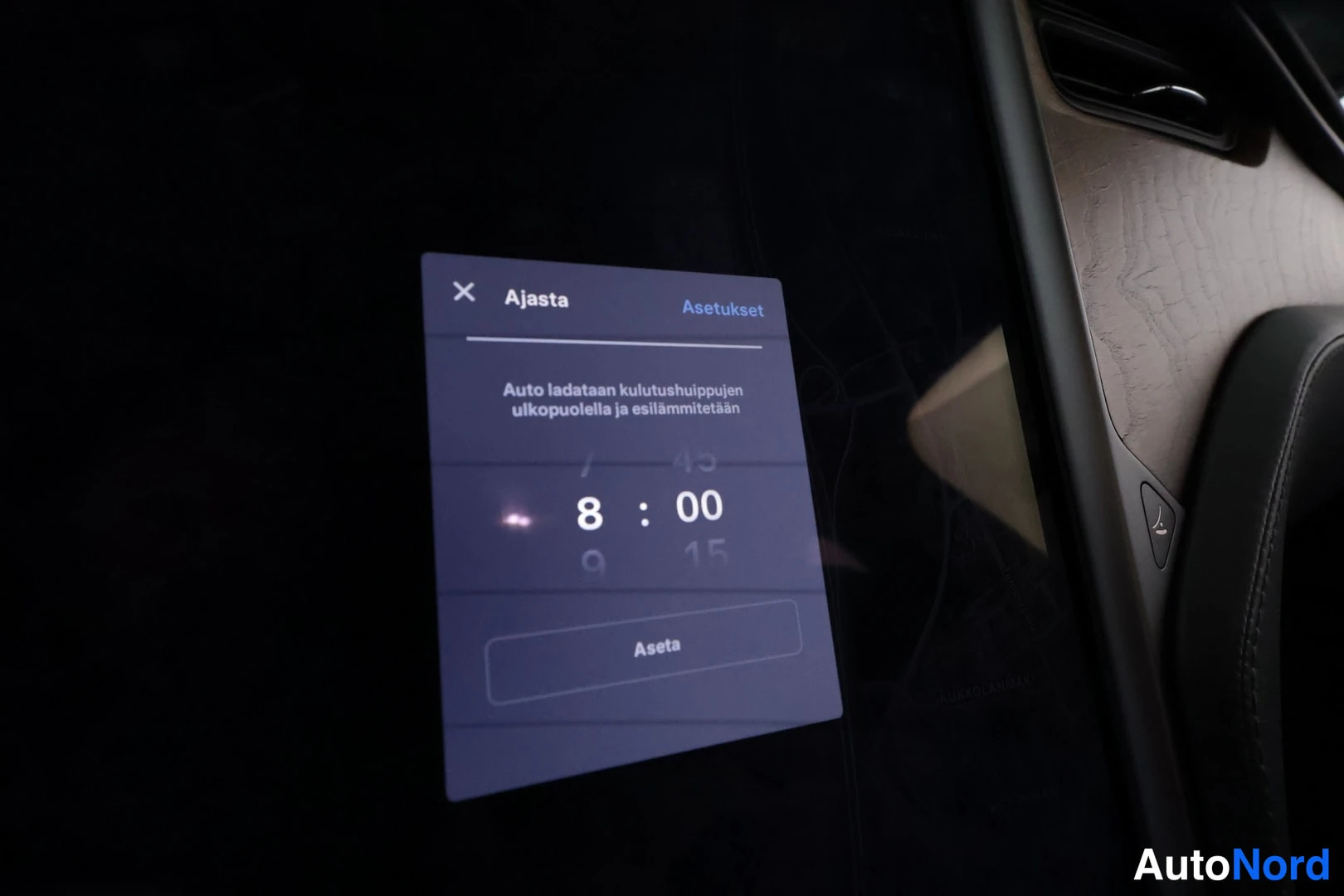 Muu: Auton kesk Näytön Ajasta-valikko, jossa kellonaika 8:00 ja teksti 'Auto ladataan kulutushuippujen ulkopuolella ja esilämmitetään'.