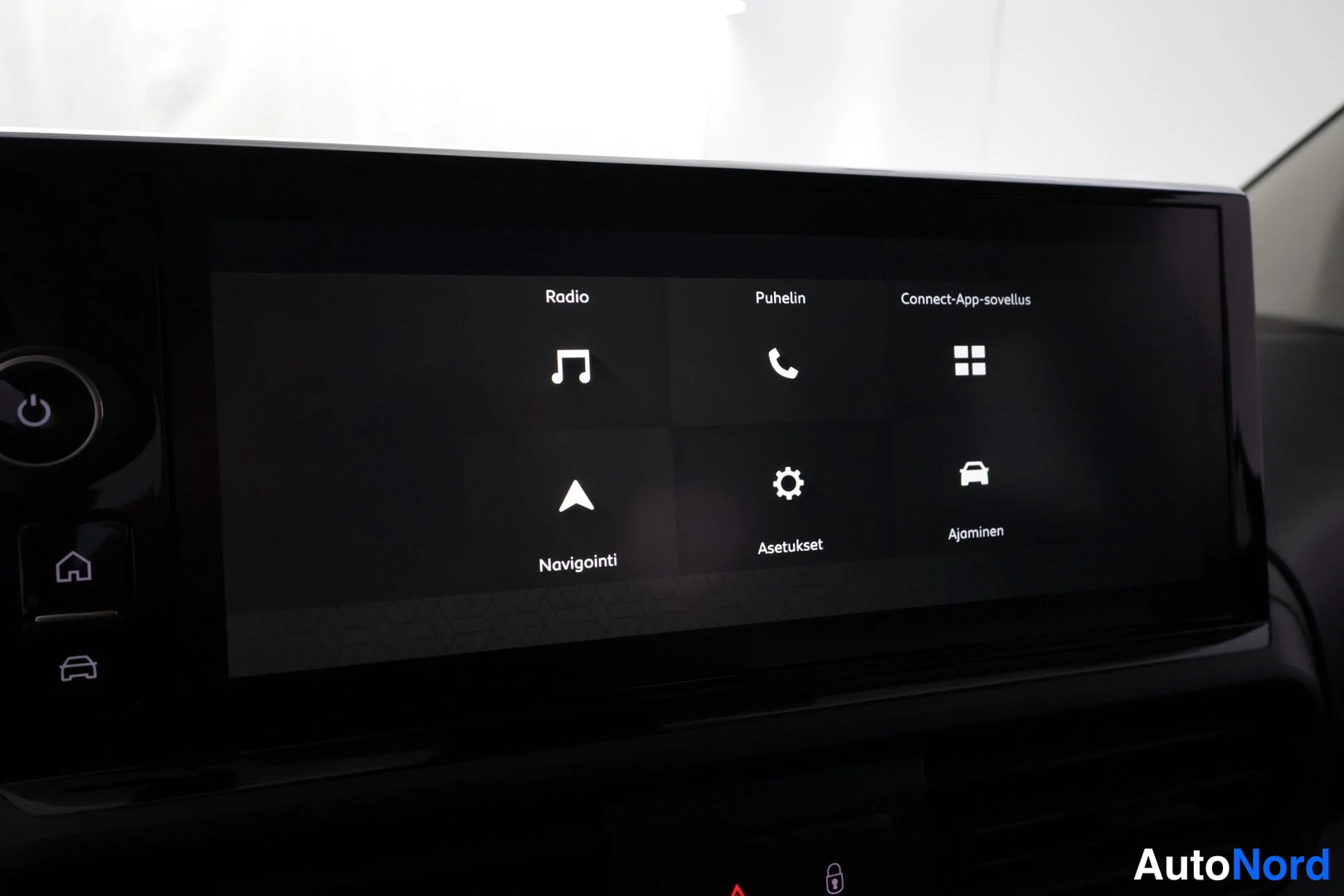 Muu: Auton kosketusnäytön päävalikko valikoilla Radio, Puhelin, Connect-App-sovellus, Navigointi, Asetukset ja Ajaminen.