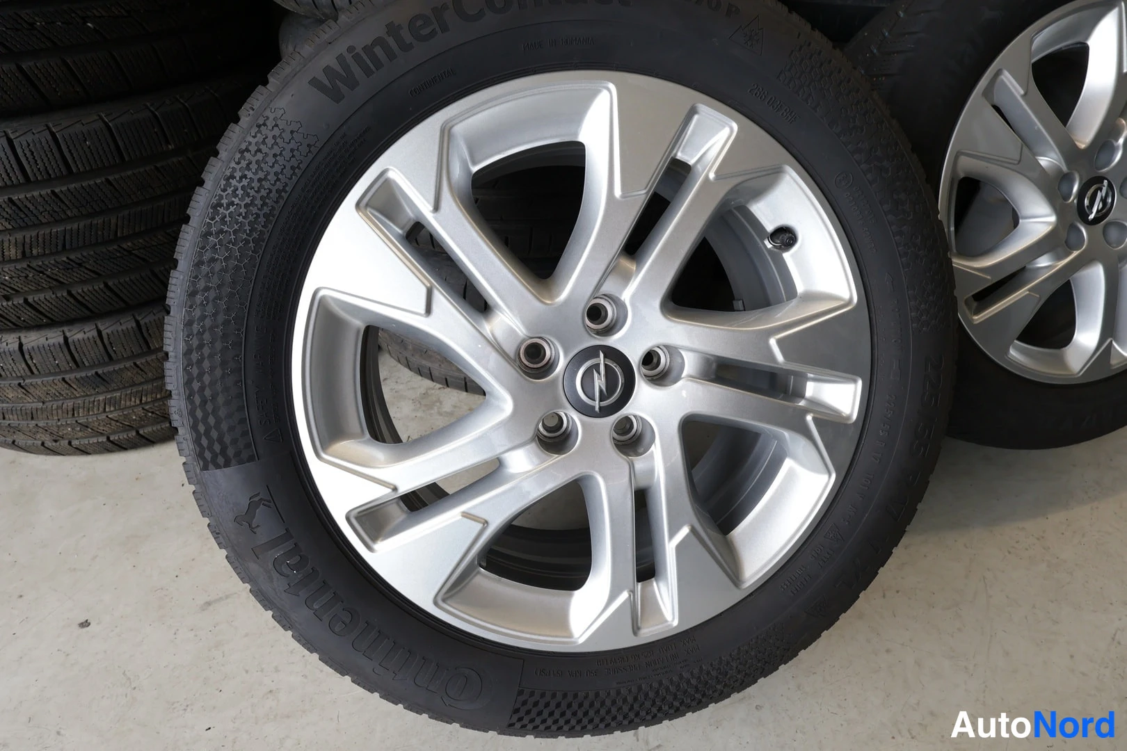 Yksityiskohta: Continental-talvirenkaat Opel-alumiinivanteilla pinossa.