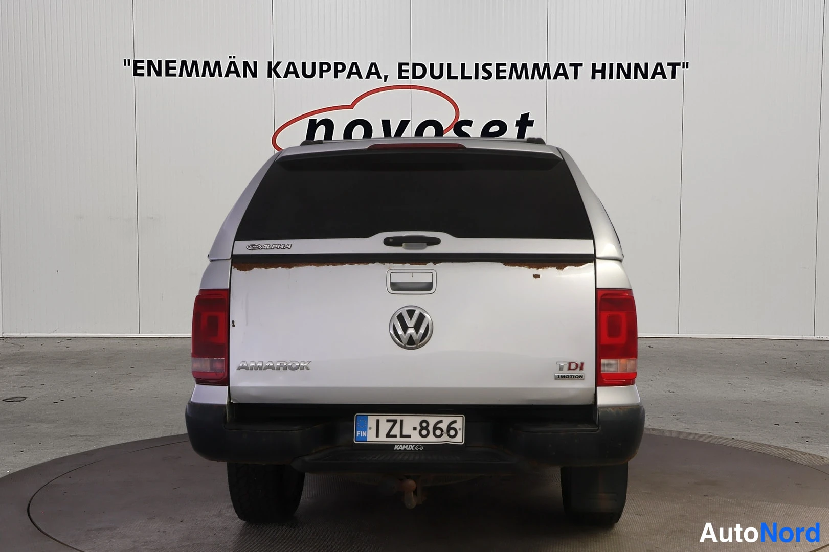 Takaa: Hopeanvärinen Volkswagen Amarok suoraan takaa, AMAROK- ja TDI 4MOTION-tunnukset ja rekisterikilpi.