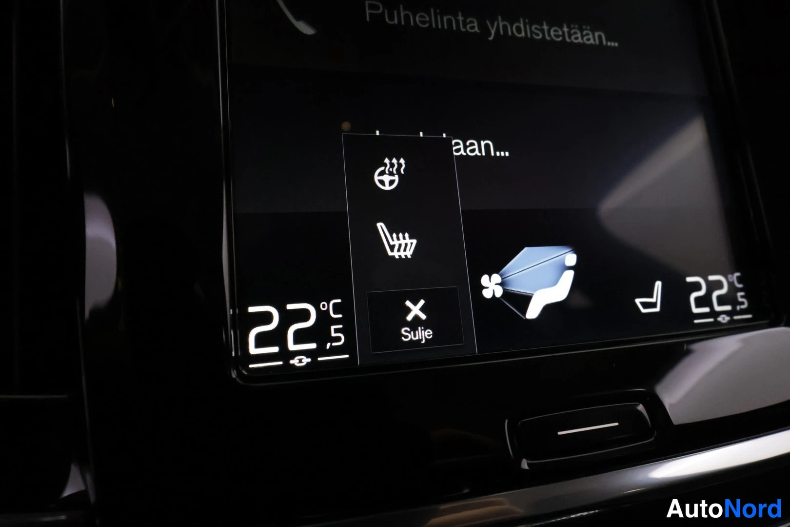 Muu: Näytön lähikuva: istuin- ja ohjauspyörän lämmitysvalikko auki, teksti 'Puhelinta yhdistetään…', lämpötila 22 °C.