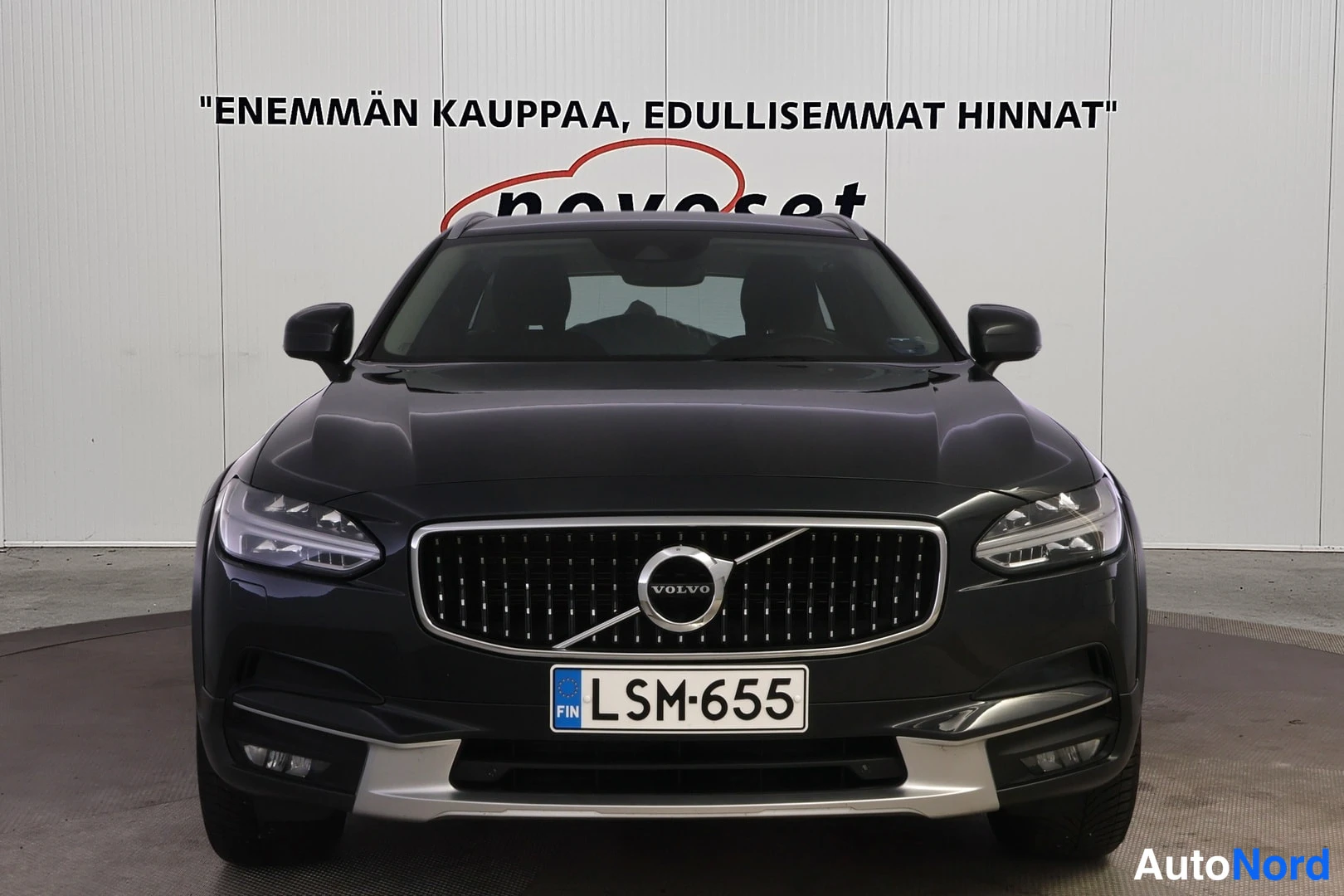 Edestä: Mustan Volvo V90 Cross Countrys suorakulmainen etuosa ja rekisterikilpi. Kuvassa näkyvät LED-valot ja kromipaneelit etupuskurissa.
