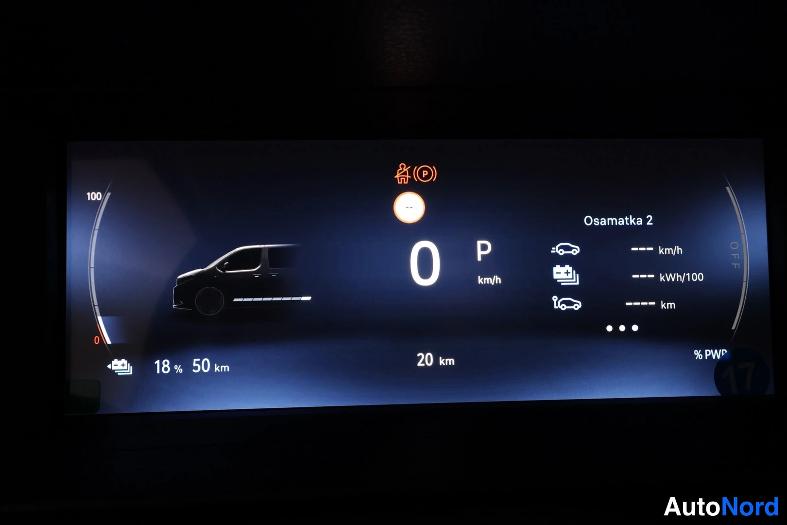 Yksityiskohta: Digitaalinen mittaristo pimeässä: energiataso 18 %, toimintamatka 50 km, matkamittari 20 km, P-vaihde.