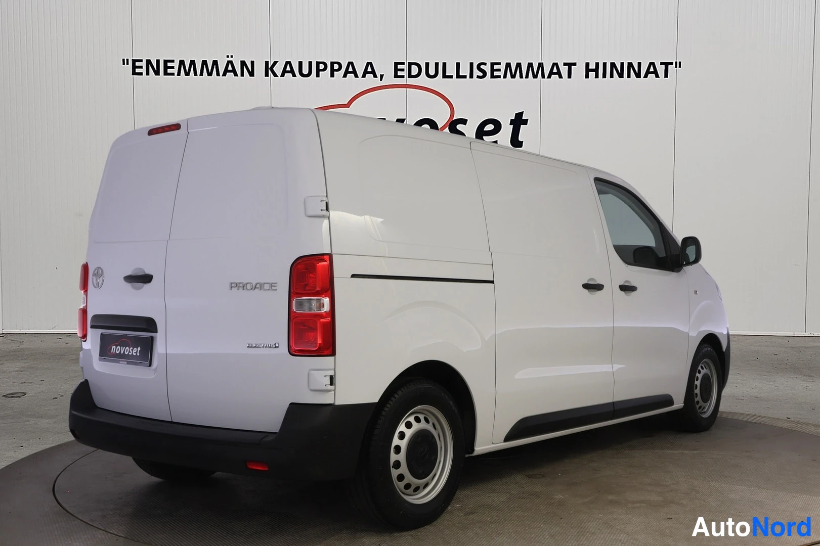 Takaviisto: Takakolmasnäkökulma valkoisesta Toyota Proace -pakettiautosta vasemmalle kääntyneenä