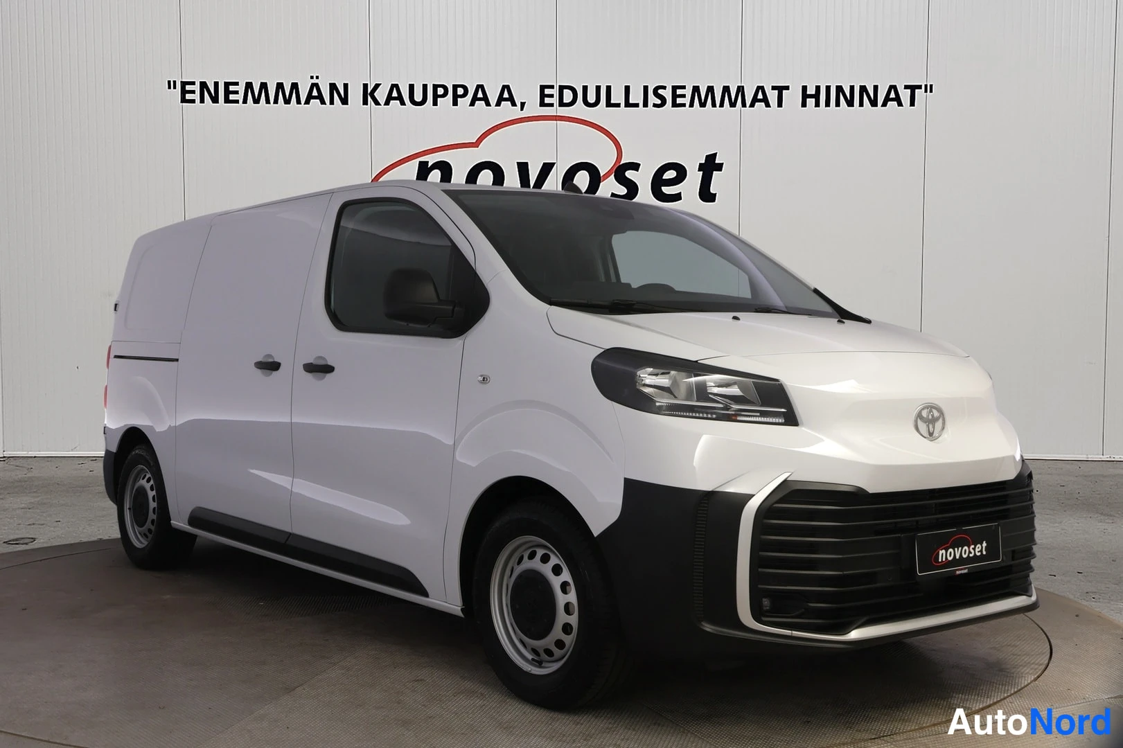 Etuviisto, nokka oikealle: Etukolmannesnäkymä valkoisesta pakettiautosta, keula kuvan oikealla: etusäleikkö, ajovalot ja vasen kylki ovineen näkyvät.