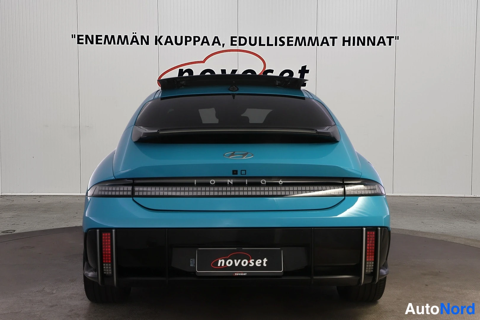 Takaa: Hyundai Ioniq 6 suoraan takaa kuvattuna; IONIQ 6 -teksti, kaksi pystysuoraa punaista takavaloa ja novoset-kyltti rekisterin paikalla.