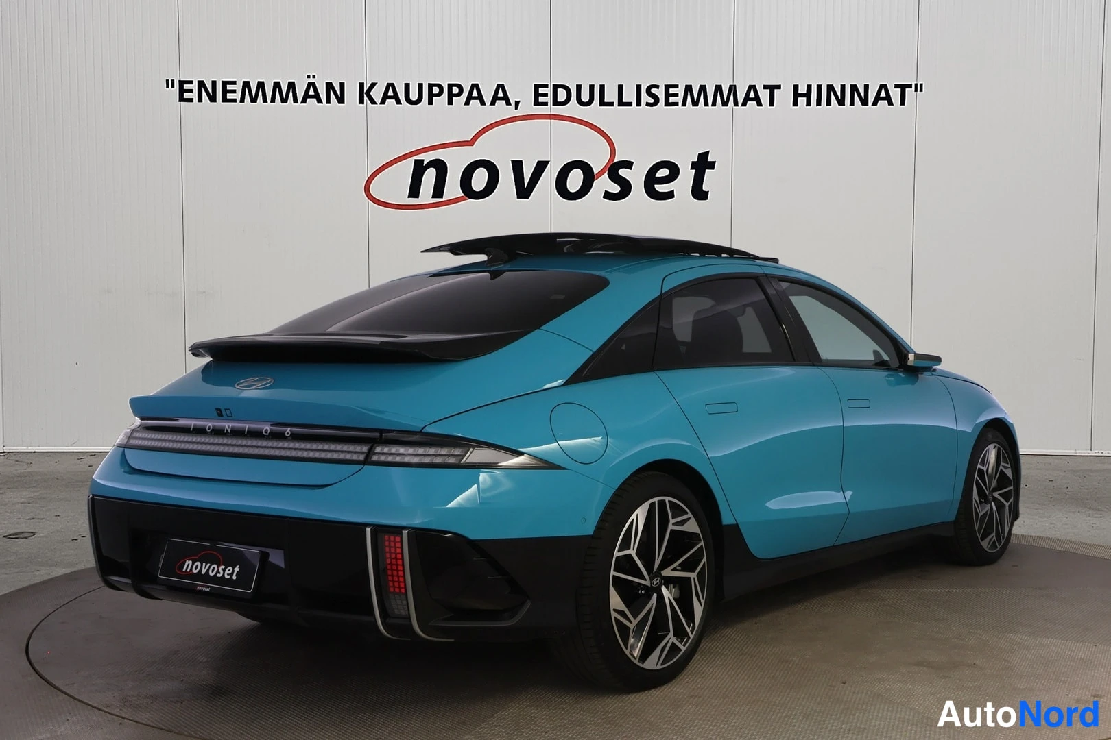 Takaviisto: Turkoosi Hyundai Ioniq 6 takaviistosta oikealta; musta takaosa ja diffuusori, pitkä takavalojiirto ja harmaat kevytmetallivanteet näkyvissä.