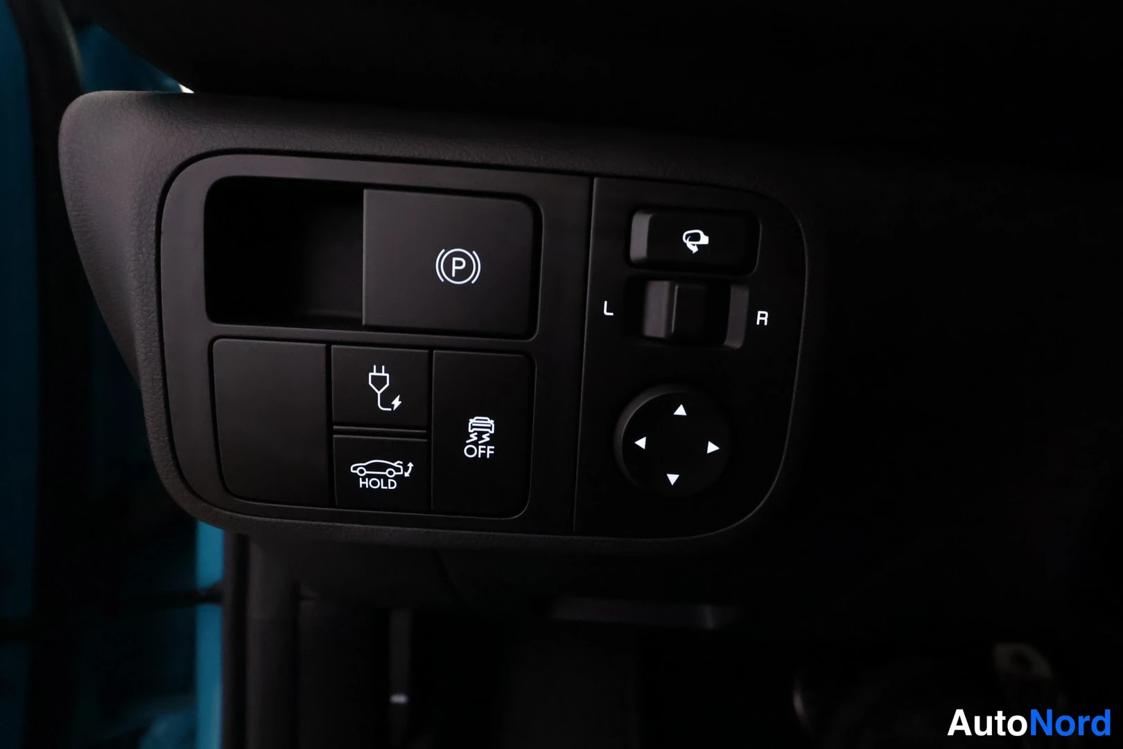 Yksityiskohta: Ohjaimien ryhmä lähikuvassa: elektroninen parkkijarrun (P) nappi, AUTO HOLD -nappi, OFF-nappi ja L/R kytkimellä varustettu pyörien ohjain.
