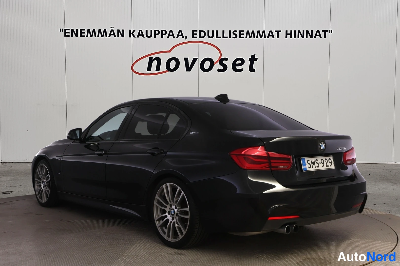Takaviisto: Musta BMW-henkilöauto takakulmasta vasemmalta kuvattuna, rekisteritunnus.