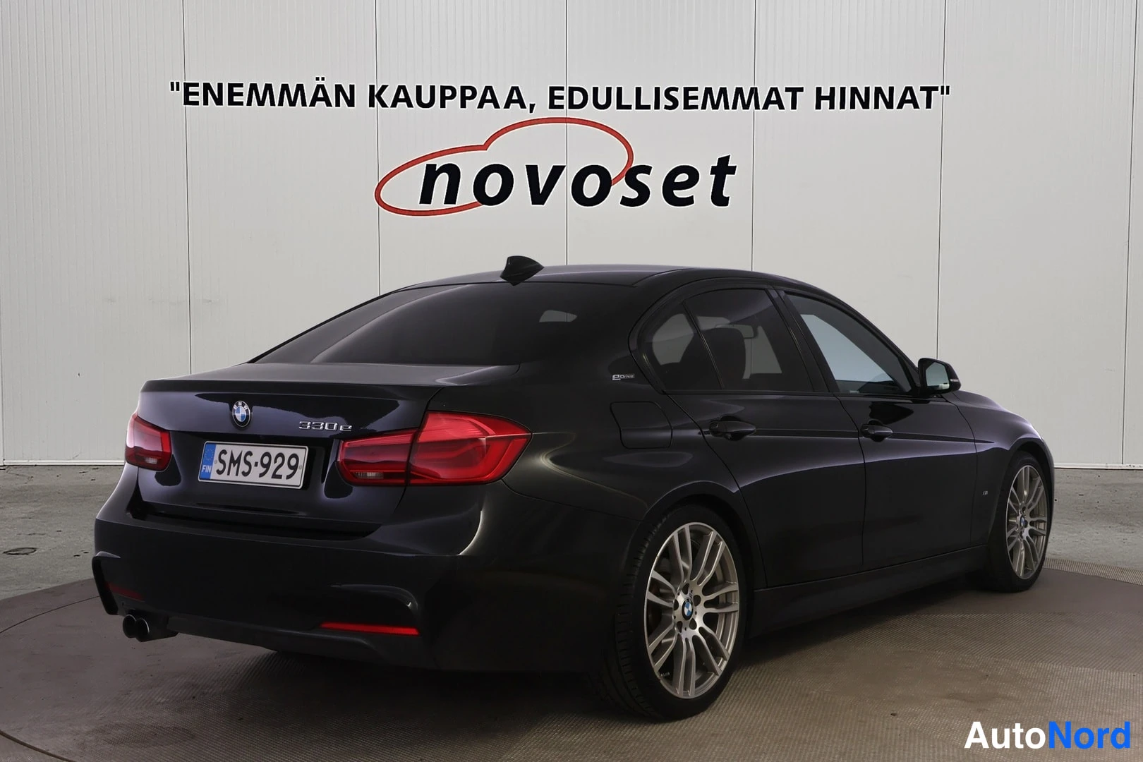 Takaviisto: Musta BMW-henkilöauto takakulmasta oikealta kuvattuna, rekisteritunnus.