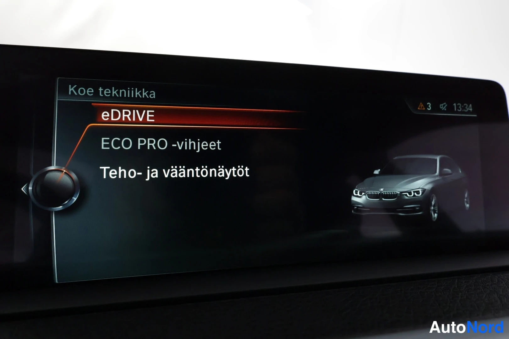 Yksityiskohta: Auton infotainment-näyttö Koe tekniikka -valikossa, eDRIVE kohta valittuna, ruudussa myös auton kuvituskuva.