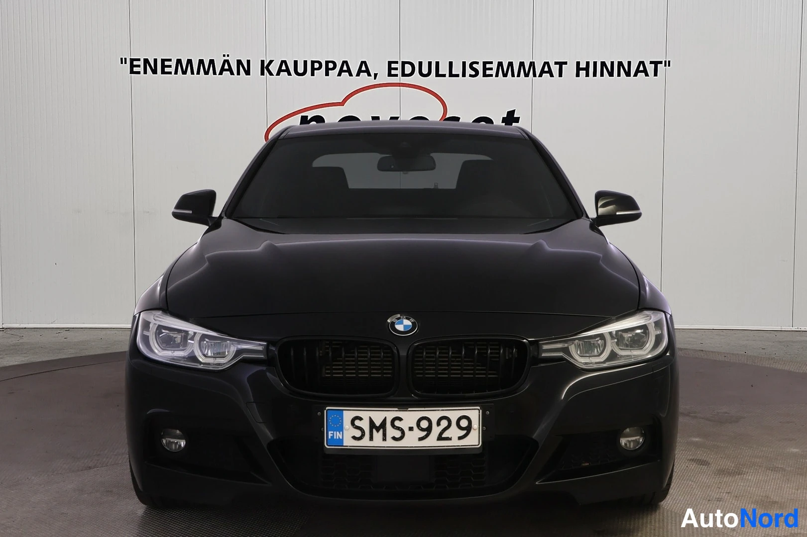 Edestä: Kuvan keskellä on auton etuosa: grille, LED-etuvalot, BMW-logo, Suomen rekisterikilpi.