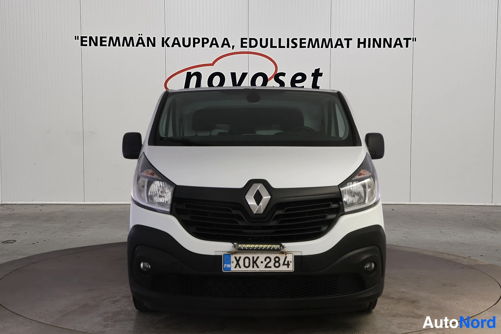 Edestä: Pakettiauto suoraan edestä: musta etusäleikkö ja Renault-merkki, ajovalot, sumuvalot ja rekisterikilpi.