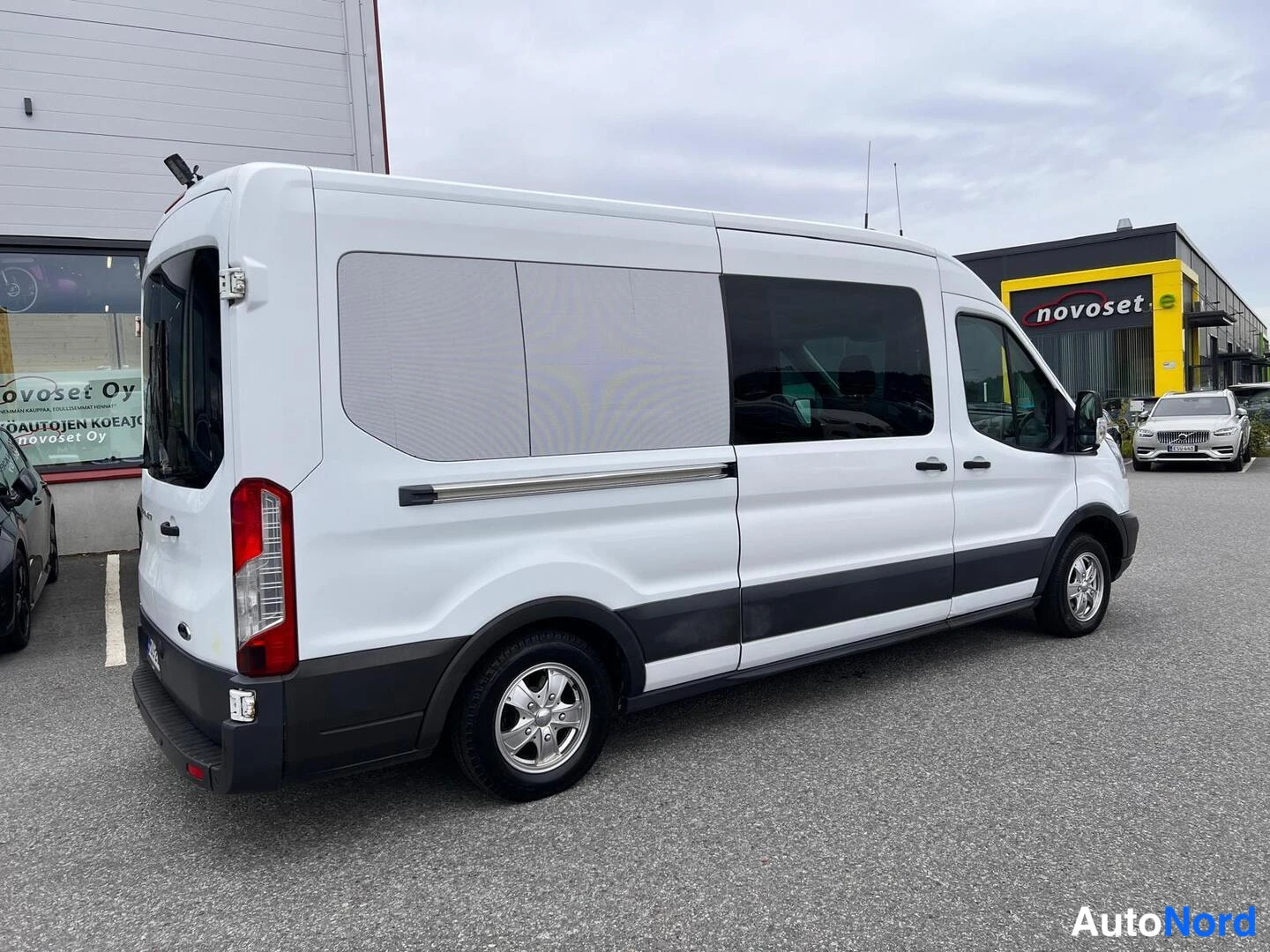 Takaviisto: Valkoinen Ford Transit -pakettiauto takaa kolmantena neljännekseksi kuvattuna, takaosa vasemmalla ja kylki näkyvissä.