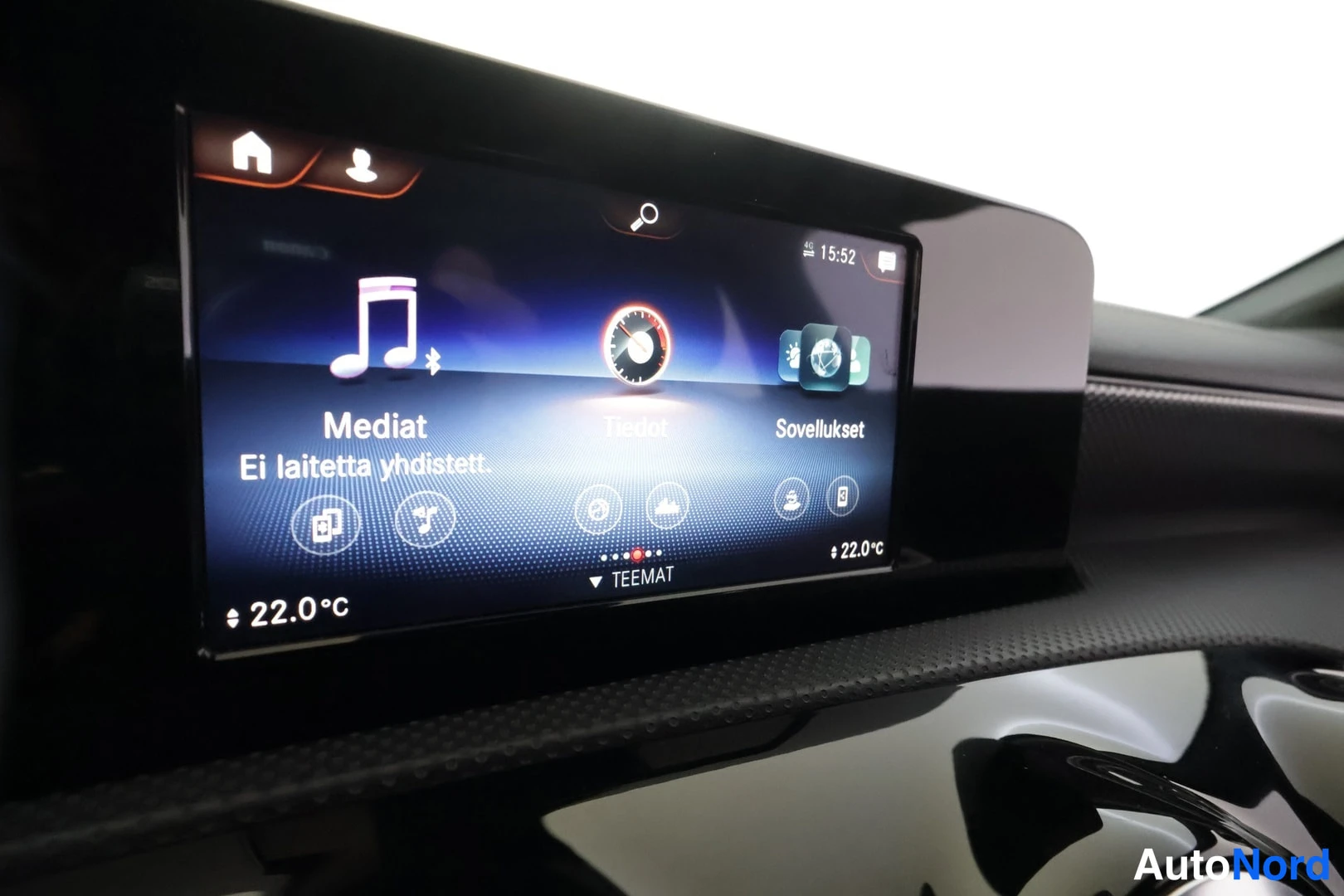 Yksityiskohta: Infotainment-näyttö, jossa valikot Mediat, Tiedot ja Sovellukset, lämpötila 22.0°C.