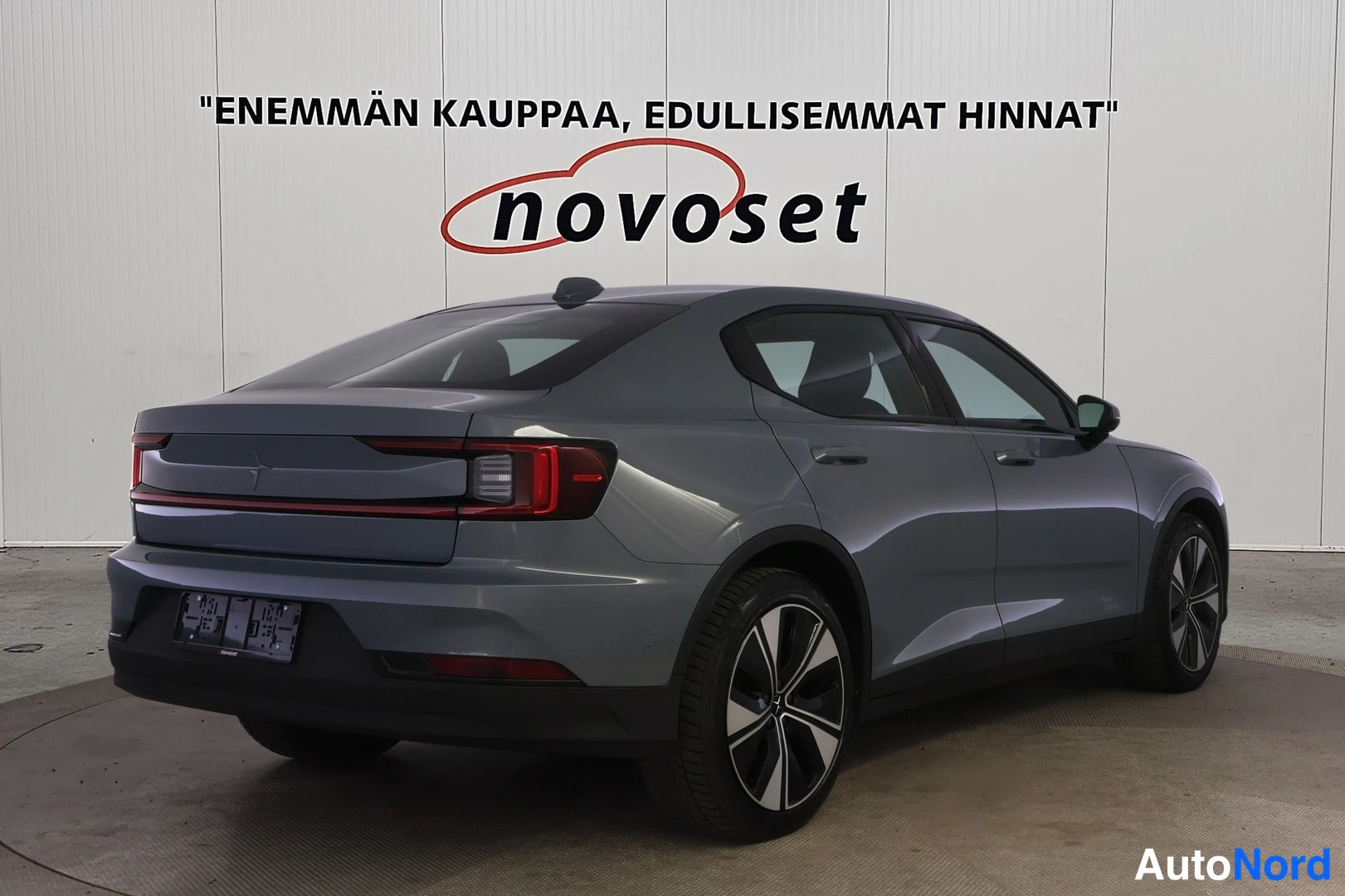 Takaviisto: Polestar 2 -sedan takakolmannesnäkymä oikealta; takavalaisin ja takaluukku vasemmalla, oikean puolen ovet ja pyörät näkyvät.