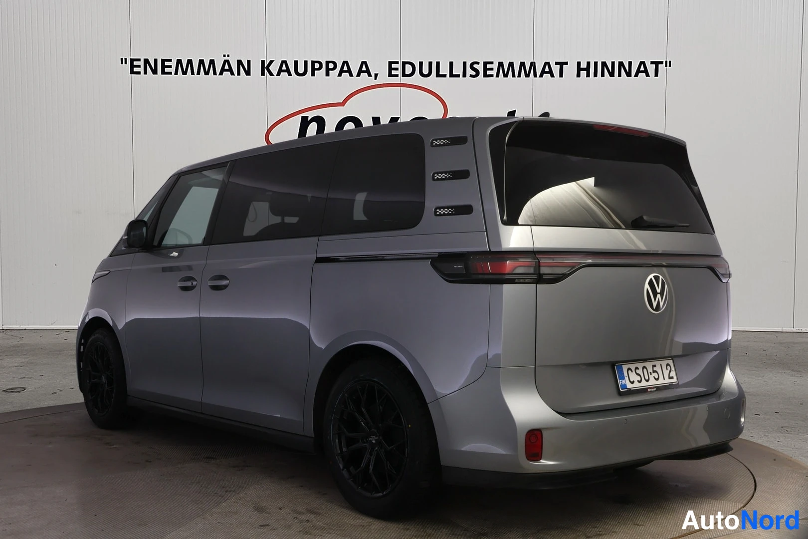 Takaviisto: Rear three-quarter view of the metallic grey Volkswagen showing dark tinted side windows, full-width taillight bar and VW badge on tailgate