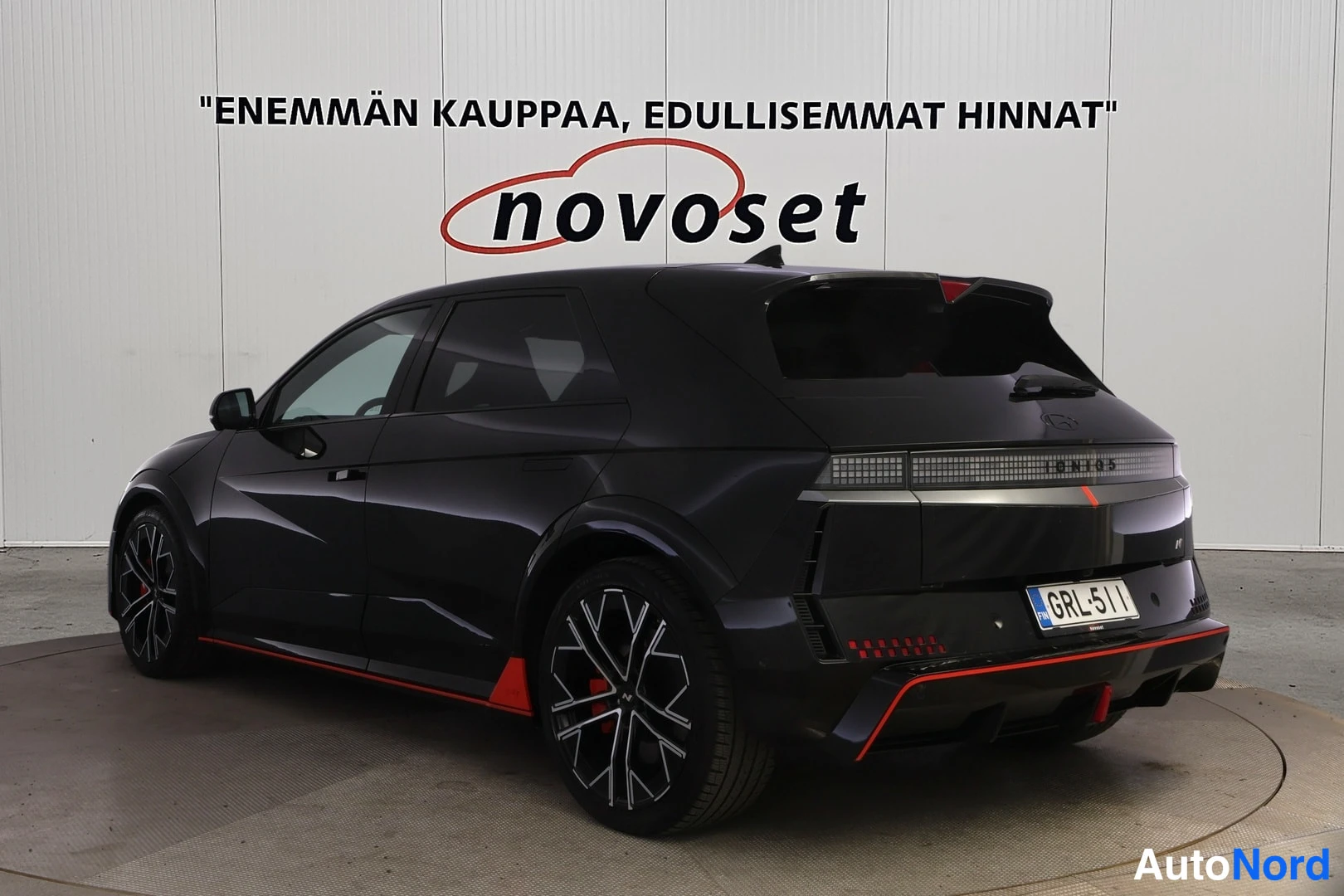 Takaviisto: Mustan Hyundai IONIQ 5:n takakulma vasemmalta, valotaulu ja punaiset sivukorostukset näkyvissä.