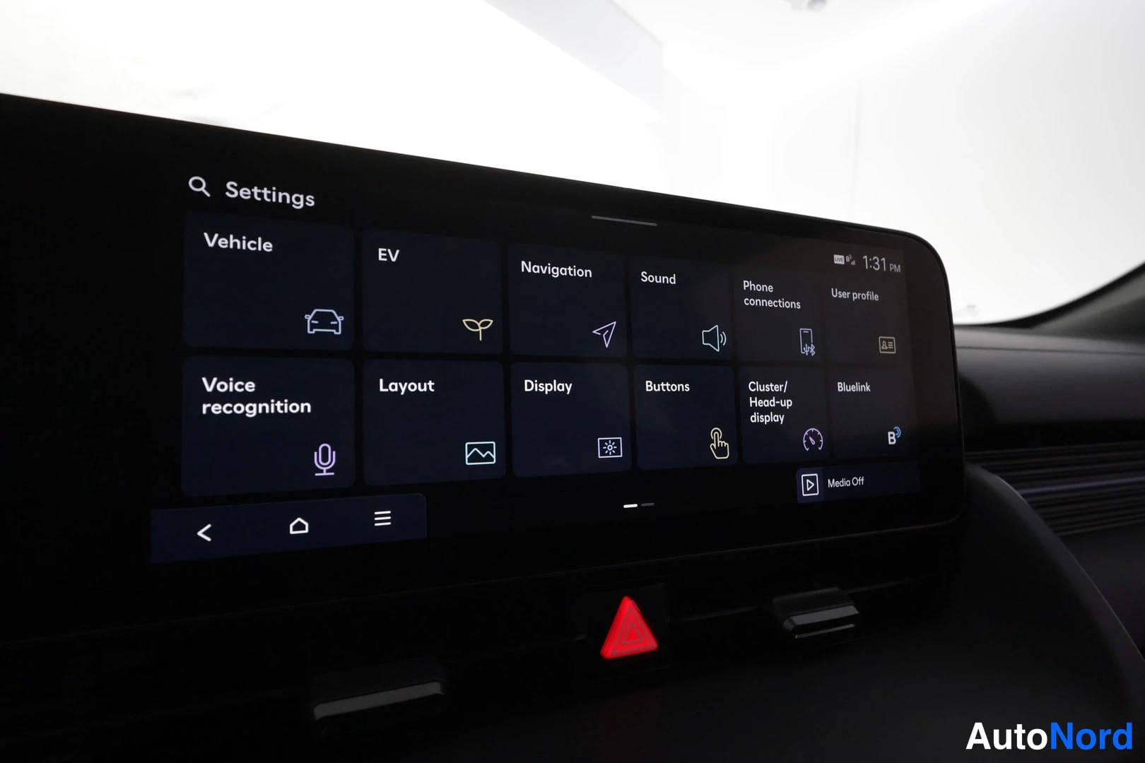 Muu: Infotainment-näytön asetukset-näkymä, jossa valikot Vehicle, EV, Navigation, Sound, Phone connections, User profile, Voice recognition, Layout, Display, Buttons