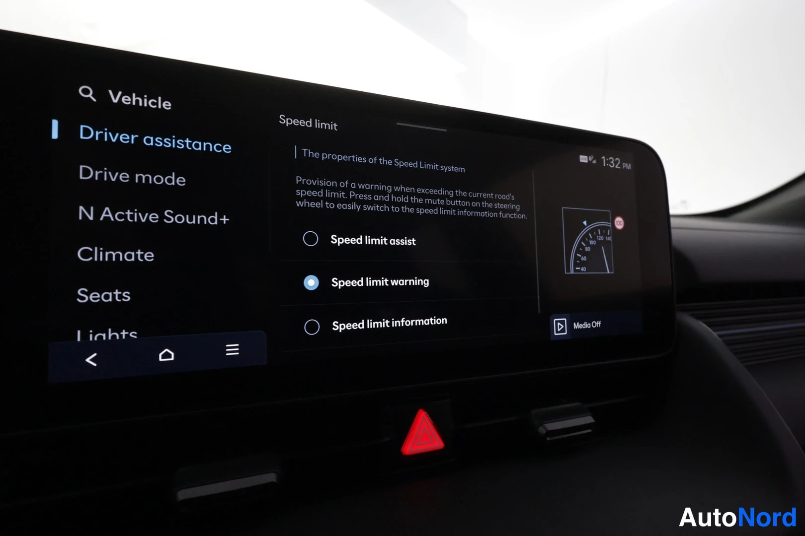 Yksityiskohta: Kojelaudan infotainment-näyttö, jossa on avattuna Vehicle-valikon Driver assistance -sivu ja Speed limit -asetukset; varoituskolmioon pohjautuva punainen painik