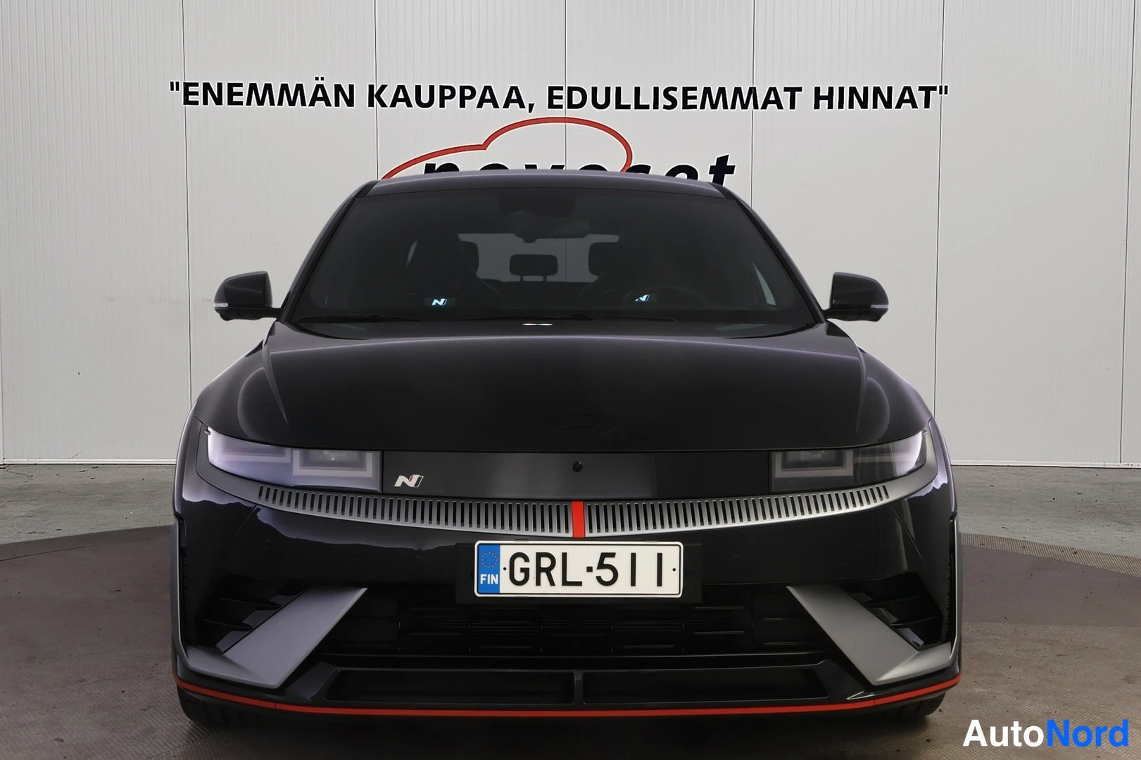 Edestä: Mustan auton suora etunäkymä, rekisterikilpi.