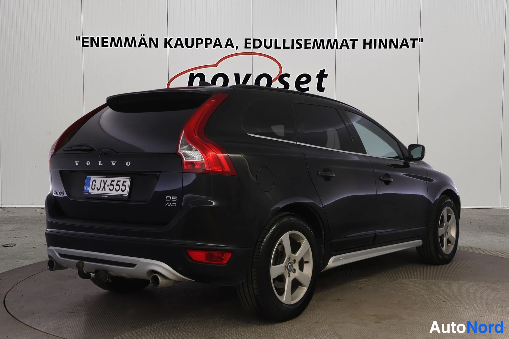 Takaviisto: Mustan Volvo XC60:n takakulma oikealta, rekisteritunnus, D5 AWD-merkintä, kattokaiteet ja hinauskoukku.