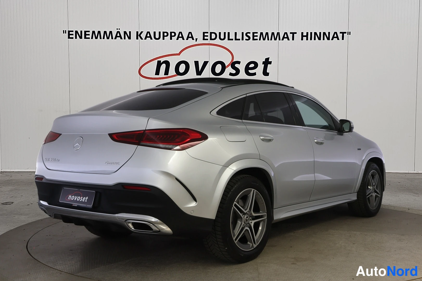 Takaviisto: Rear three-quarter view of the silver vehicle from the passenger side, showing the roof rails, rear window, C-pillar, passenger door and rear wheel.