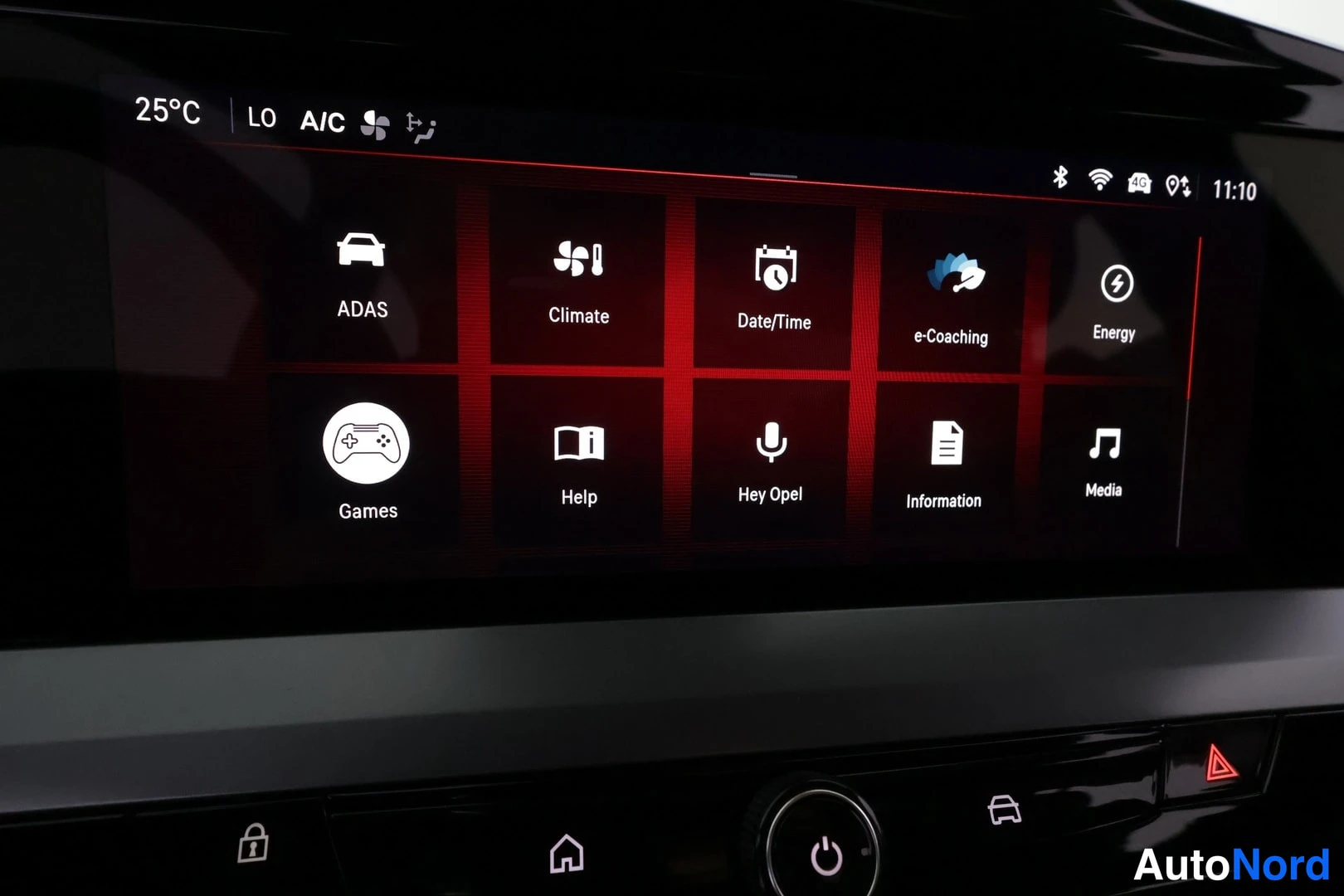 Yksityiskohta: Close-up of the car's central touchscreen infotainment system displaying an application grid menu. Icons visible include ADAS, Climate, Date/Time, e-Coaching, E