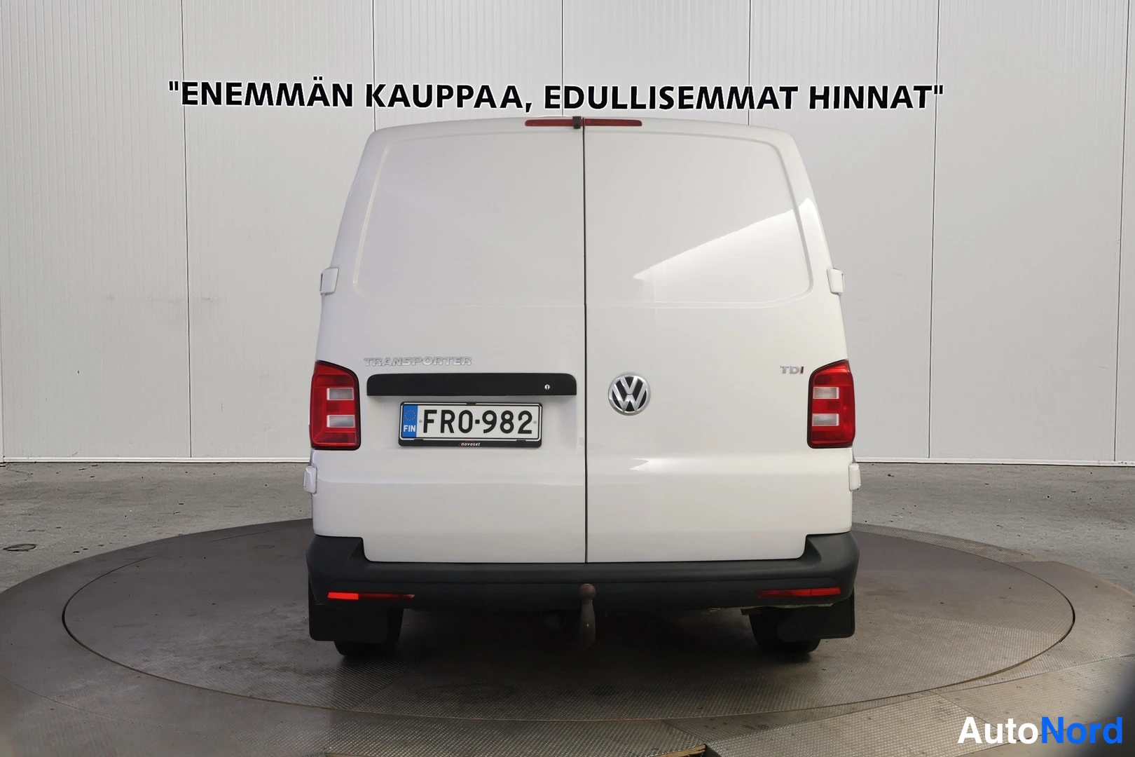 Takaa: Valkoinen pakettiauto suoraan takaa, rekisteritunnus, takaovi auki näkyvissä.