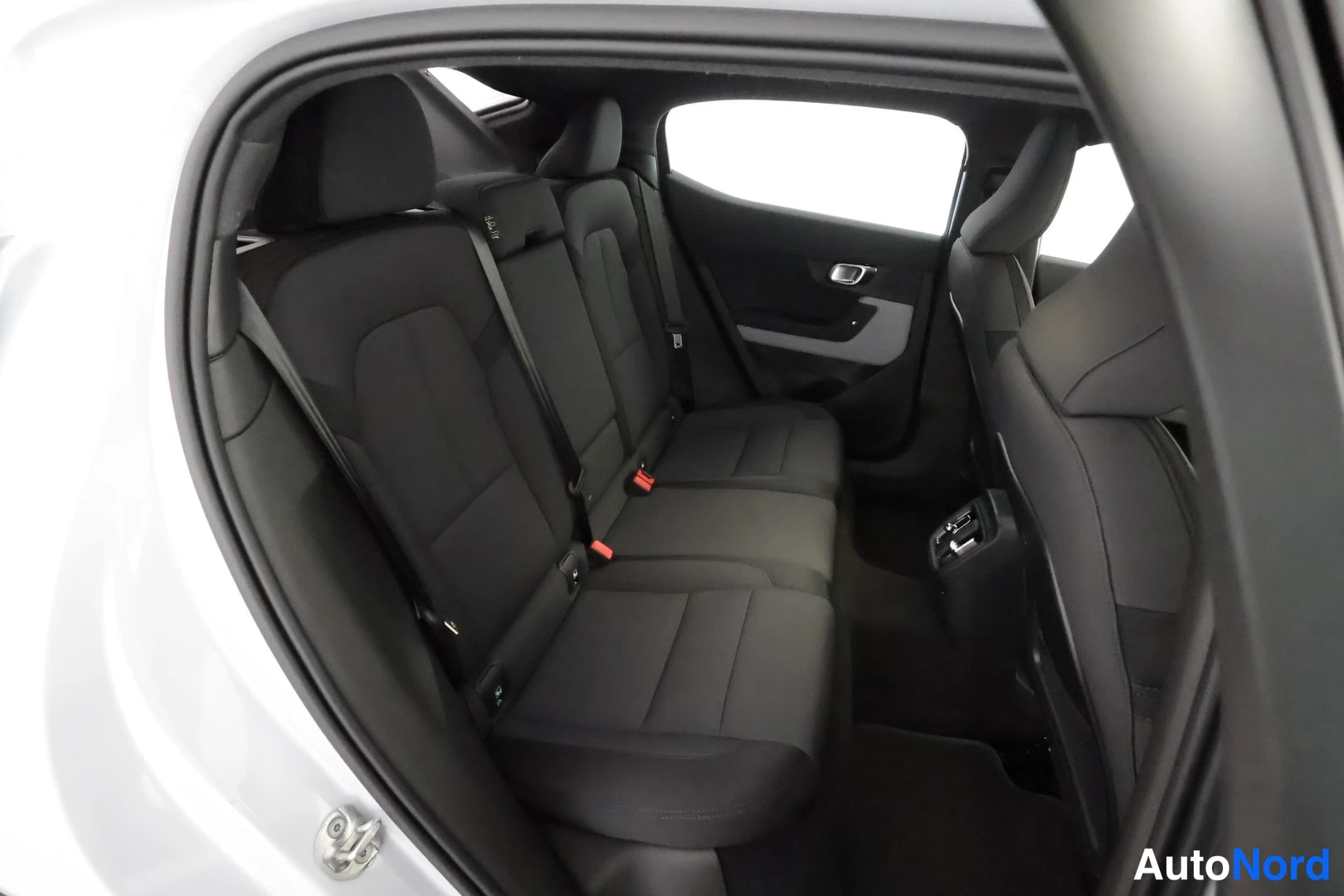 Takaistuimet: Rear seat interior view. Shows the bench-style rear seats, headrests, and an ISOFIX anchor point on the side of the center seat cushion.