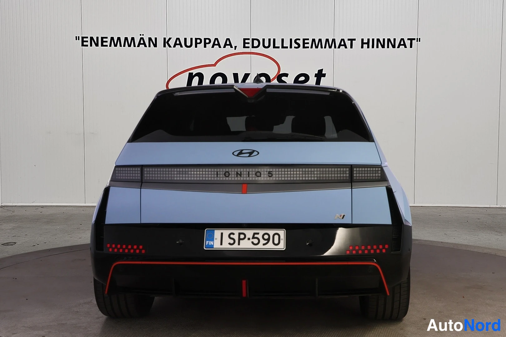 Takaa: Vaaleansininen auto suoraan takaa, Ionio 5 -malli, rekisterikilpi ja punaiset sumuvalojen korostukset.