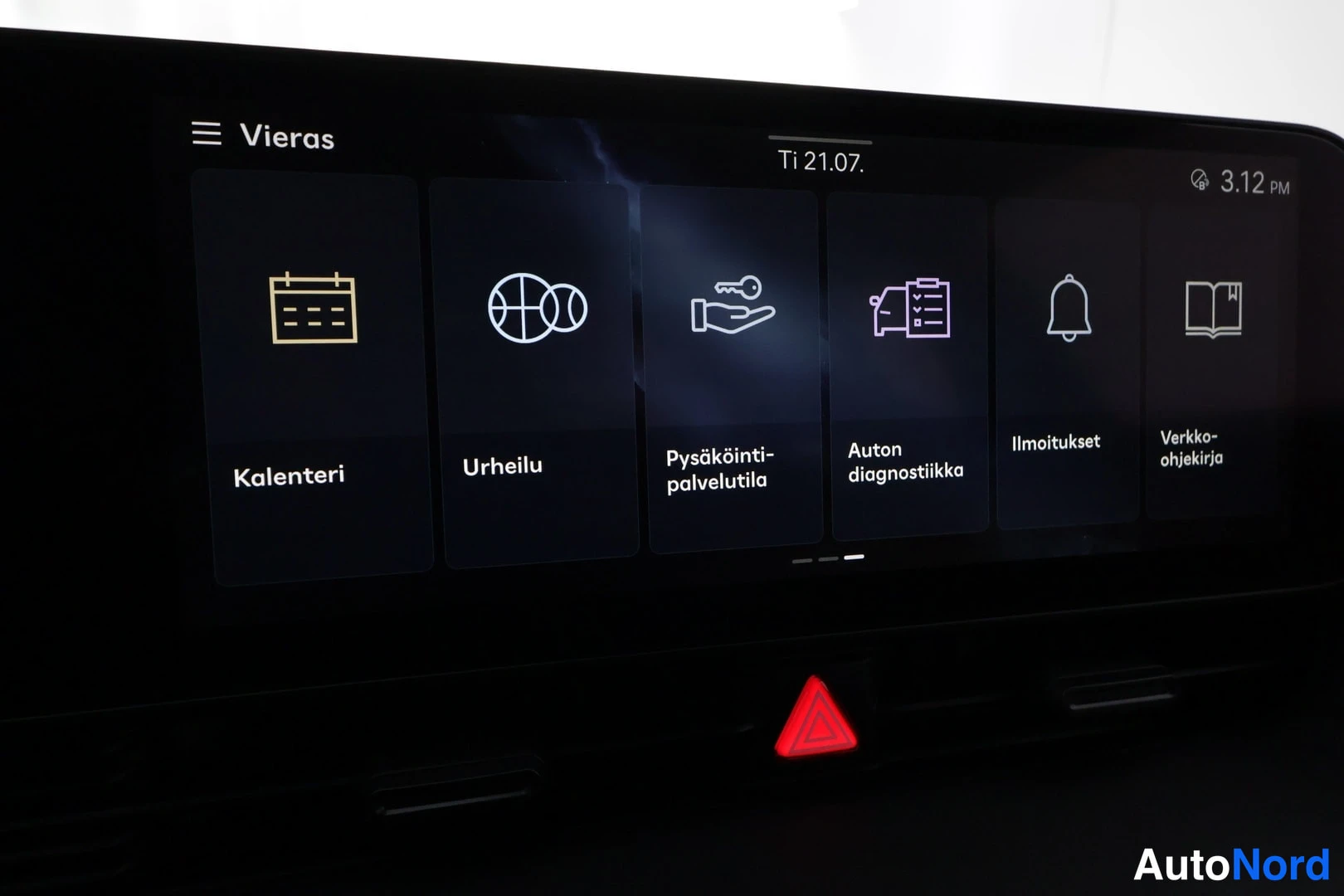 Yksityiskohta: Infotainment-näytön sovellussivu kuvakkeilla Kalenteri, Urheilu, Pysäköintipalvelutila, Auton diagnostiikka, Ilmoitukset ja Verkko-ohjekirja, yläreunassa Ti 21.