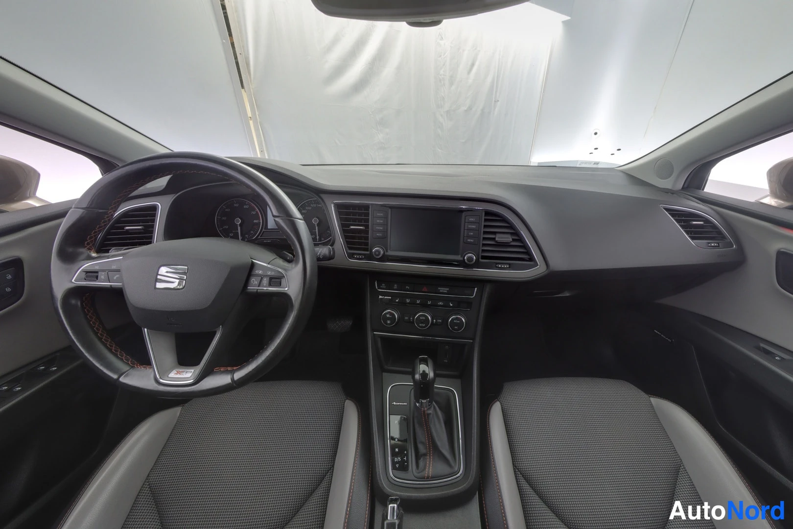 Muu: Seat-henkilöauton sisätilat ja kojelauta kuljettajan paikasta: mittaristo, mediasäädin ja automaattivaihteiston vaihdekeksi näkyvät.