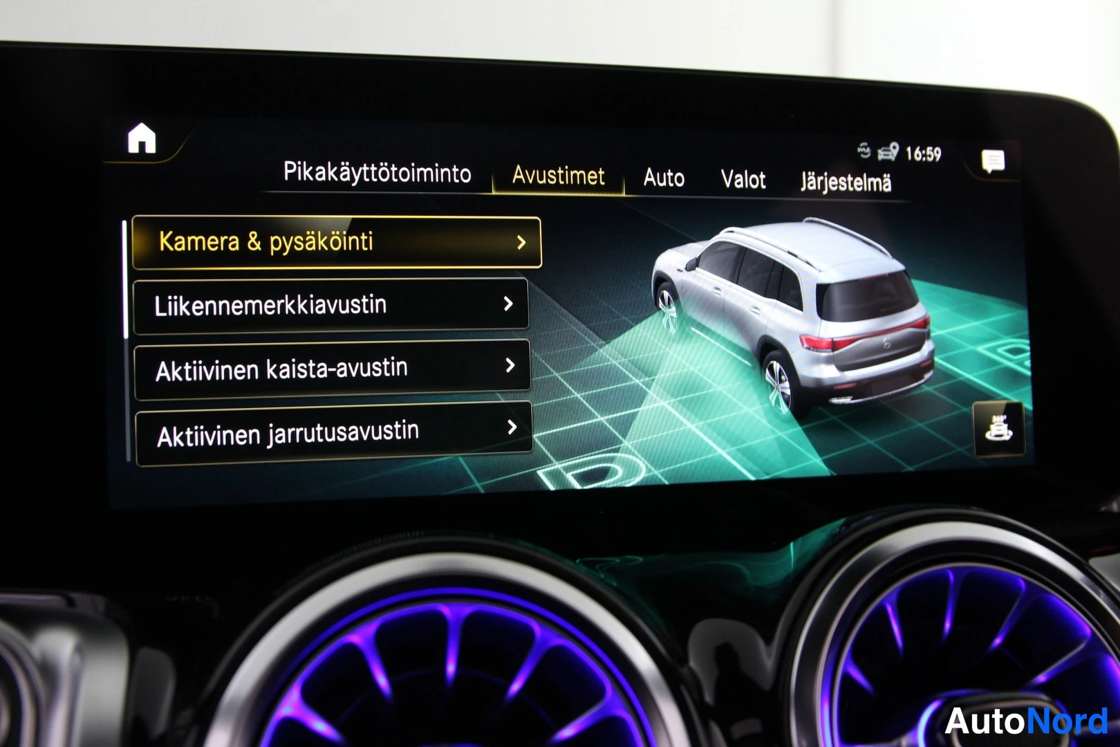 Muu: Mercedes-Benzin ohjaamon näyttö Avustimet-valikossa, jossa valittuna Kamera & pysäköinti ja listattuna liikennermkiaustin sekä aktiiviset kaista- ja jarrutusavu