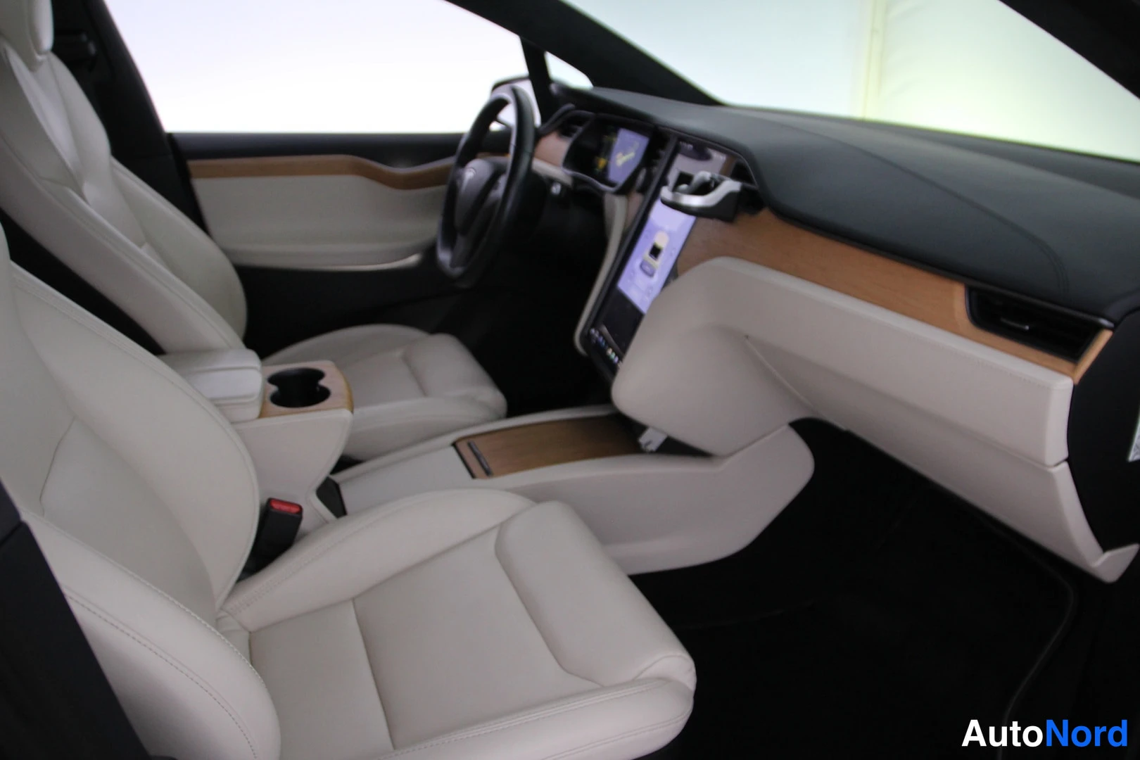 Etuistuimet: Cabin view from driver side showing dashboard, steering wheel, center console, and cream leather front seats