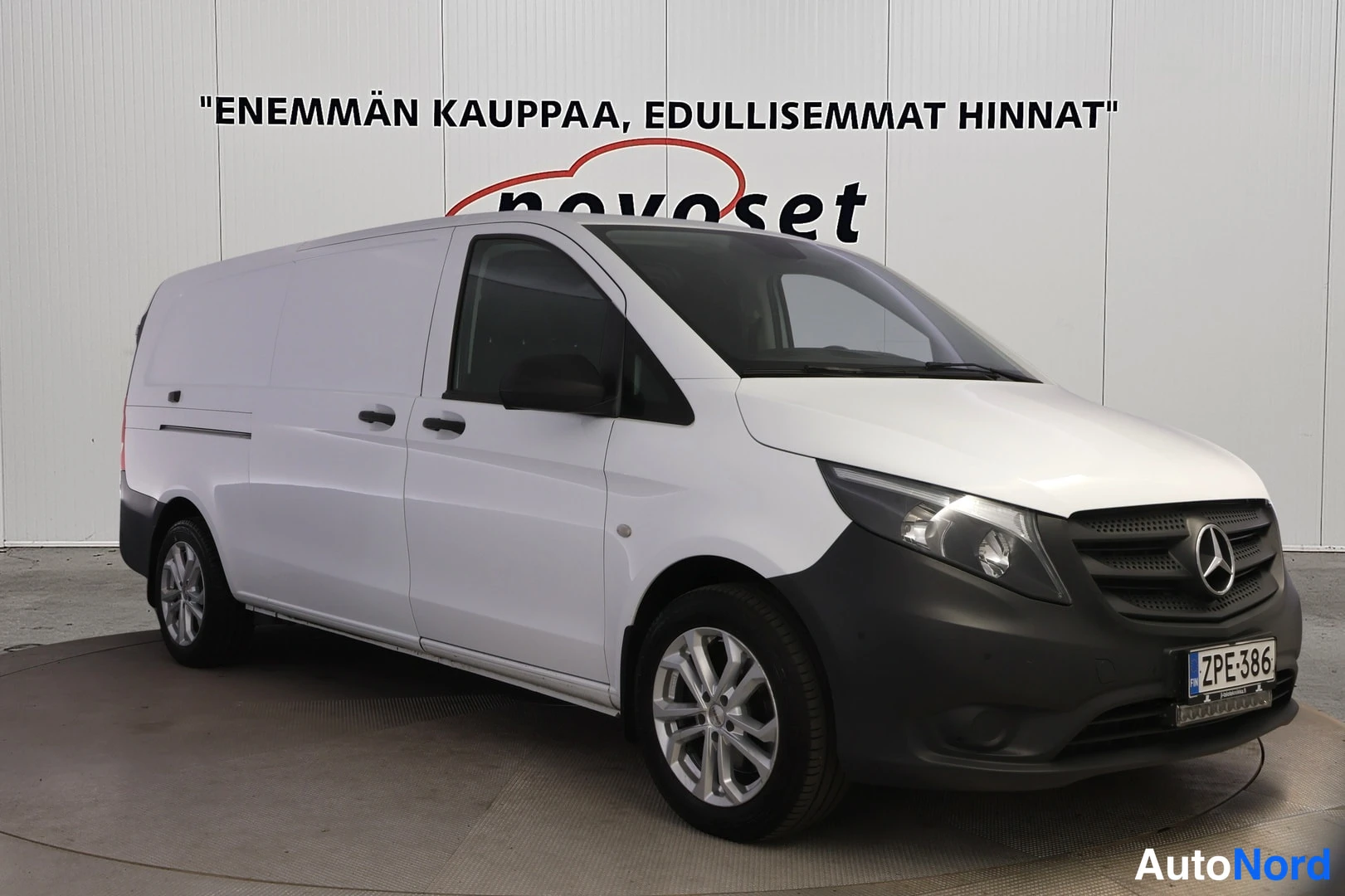 Etuviisto, nokka oikealle: Valkoinen pakettiauto kolmannes­etunäkymässä, keula oikealla, musta etupanssari ja hopeiset vanteet.