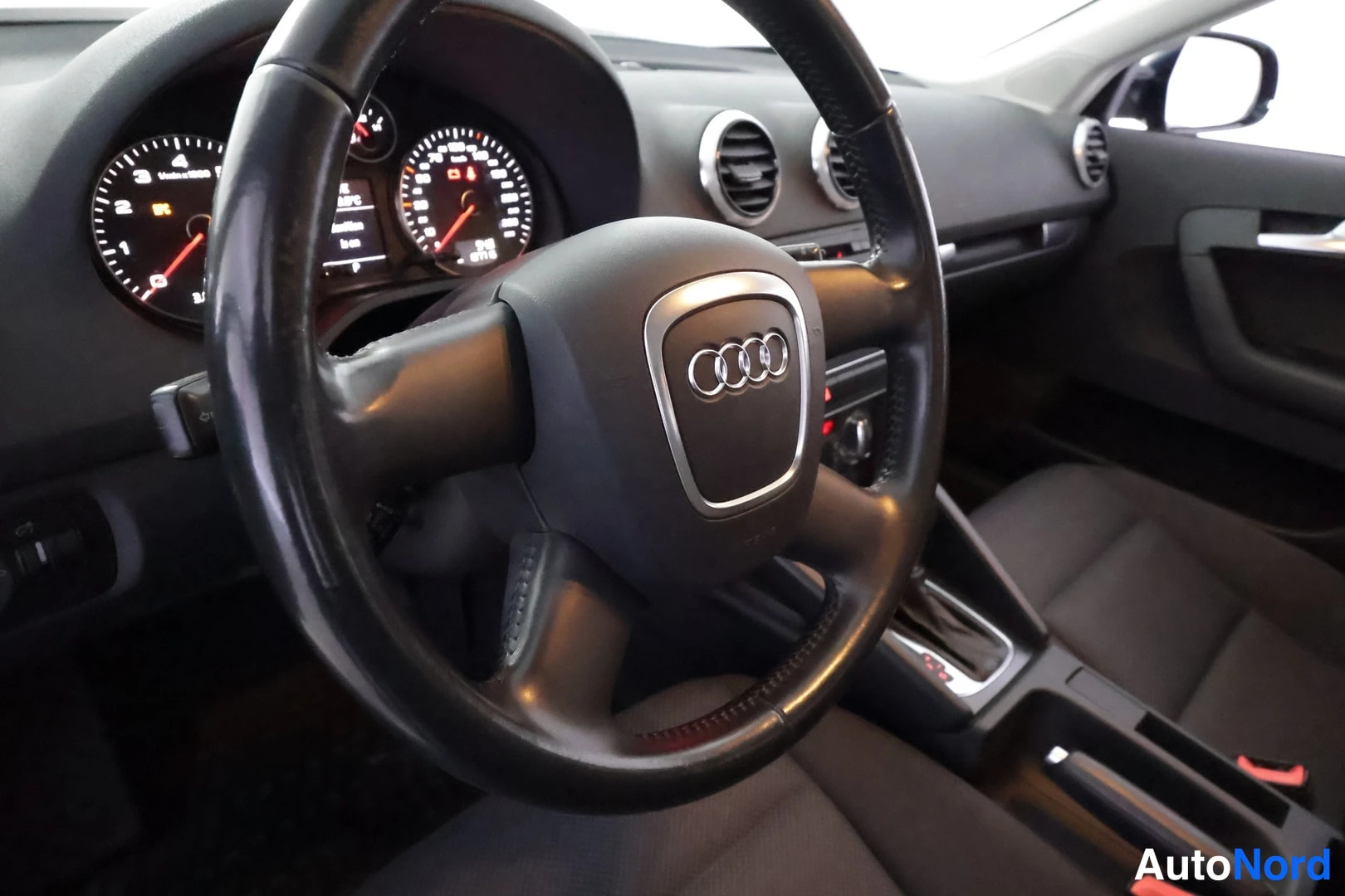 Muu: Audi-merkitty ohjauspyörä, mittaristo ja kojelaudan tuuletusaukot, tummat kangaspenkit, automaattivaihteen keila.