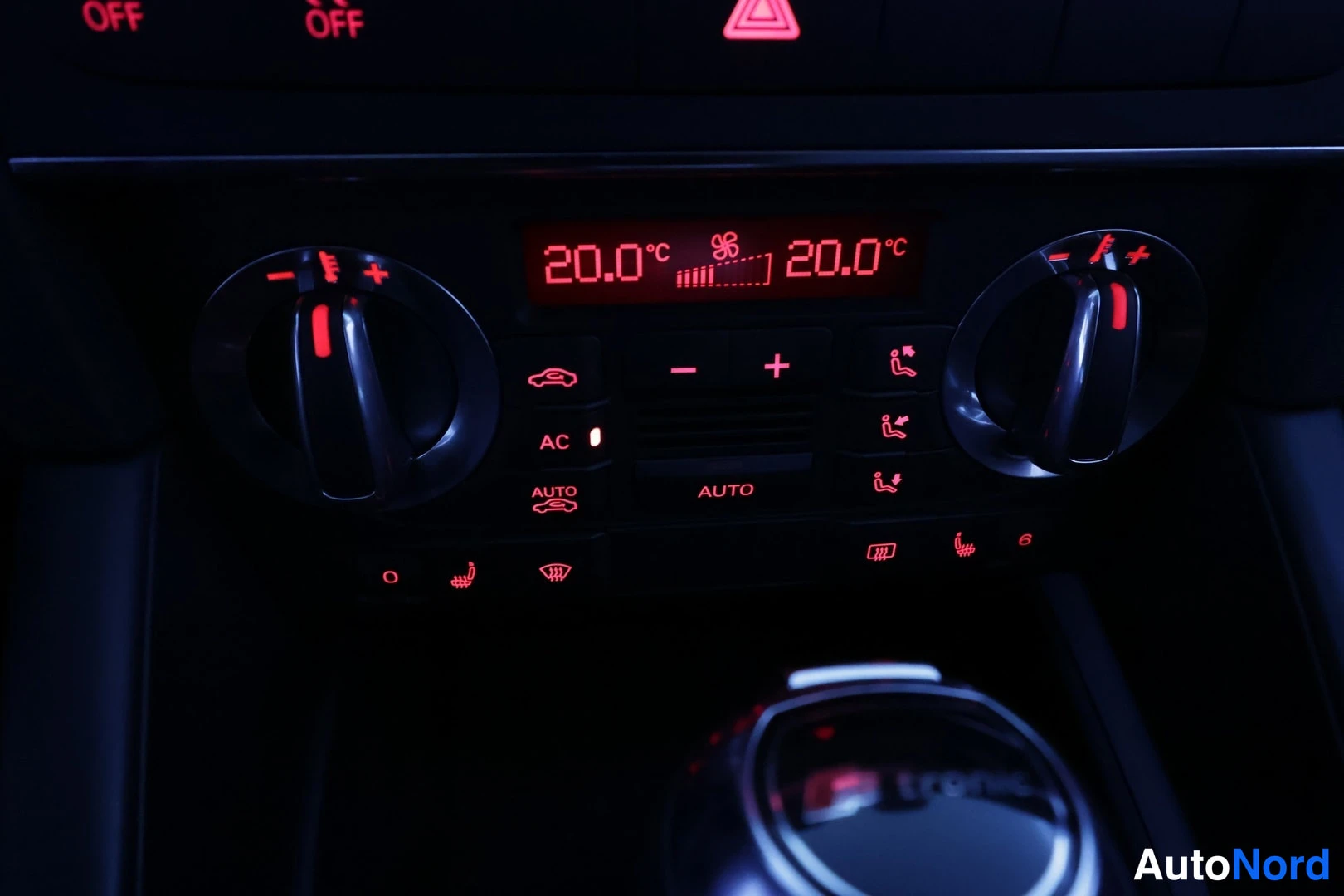 Muu: Punaisella valaistu ilmastointipaneeli näyttää 20,0 °C:n lämpötilan molemmilla puolilla; AC-, AUTO-, ilmanohjaus- ja istuinlämmitysnapit näkyvät, alareunassa va