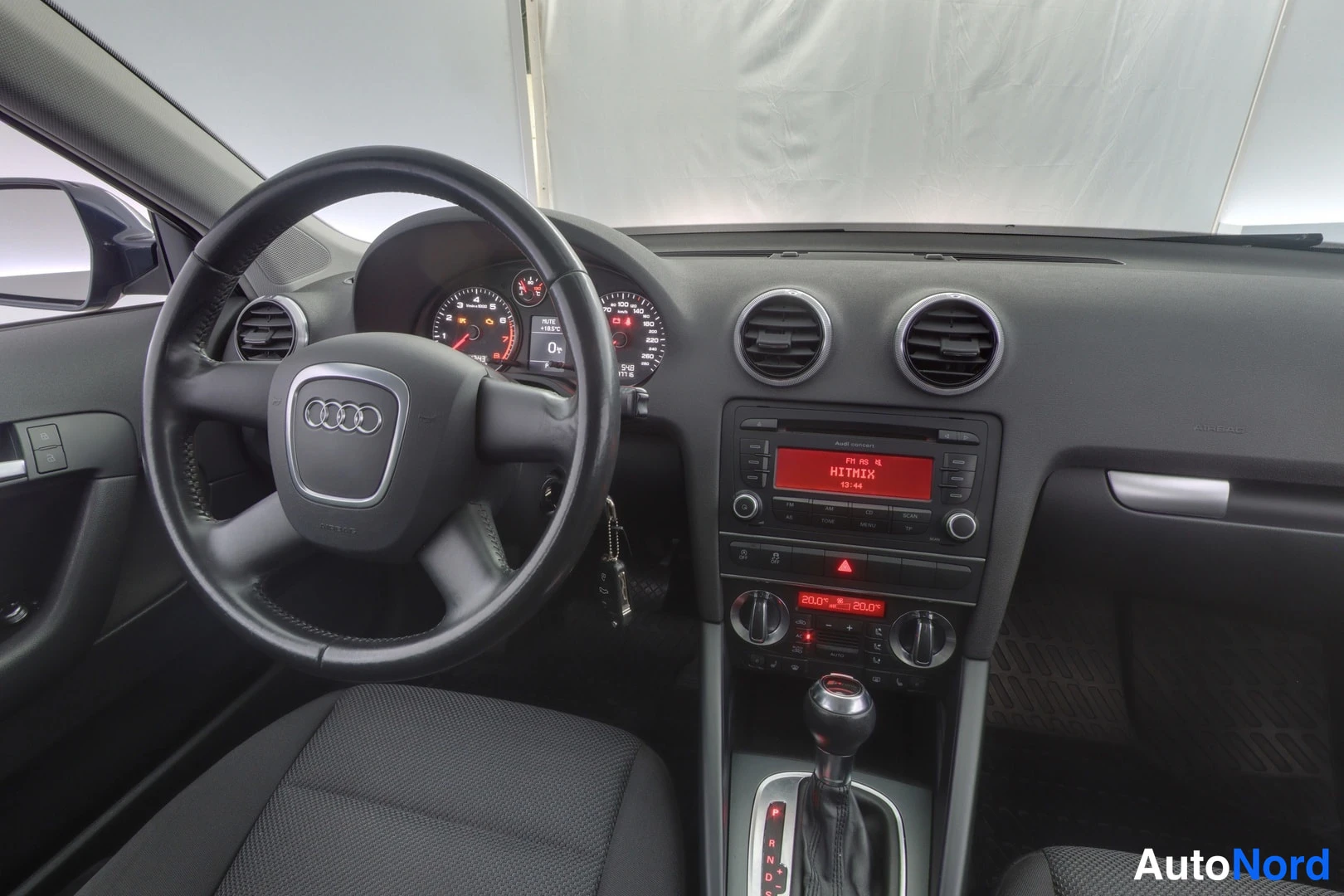 Muu: Lähikuva Audi A3:n ohjauspyörästä, mittaristosta ja radion näytöstä, jolla lukee HIT MIX.