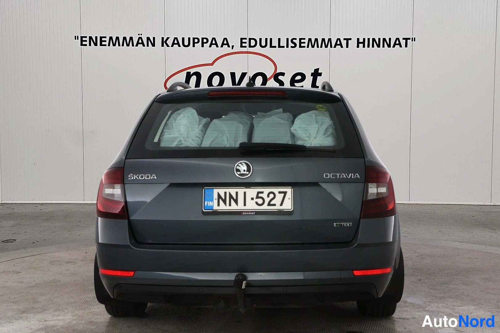 Takaa: Tummanharmaan Skoda Octavian suora takakuva; takakannessa ŠKODA- ja OCTAVIA-merkit, rekisteritunnus, takilainuri ja vetokoukku.