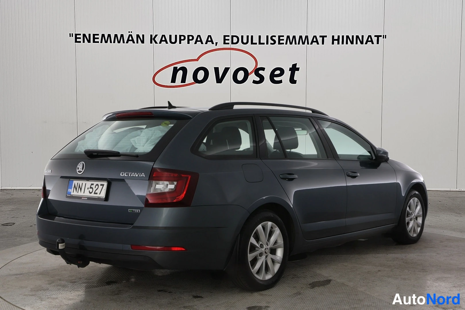 Takaviisto: Tummanharmaa Skoda Octavia -farmari takaviistosta oikealta; näkyvissä takavalot, kattokaiteet, takilainuri, vetokoukku ja kevytmetallivanteet.