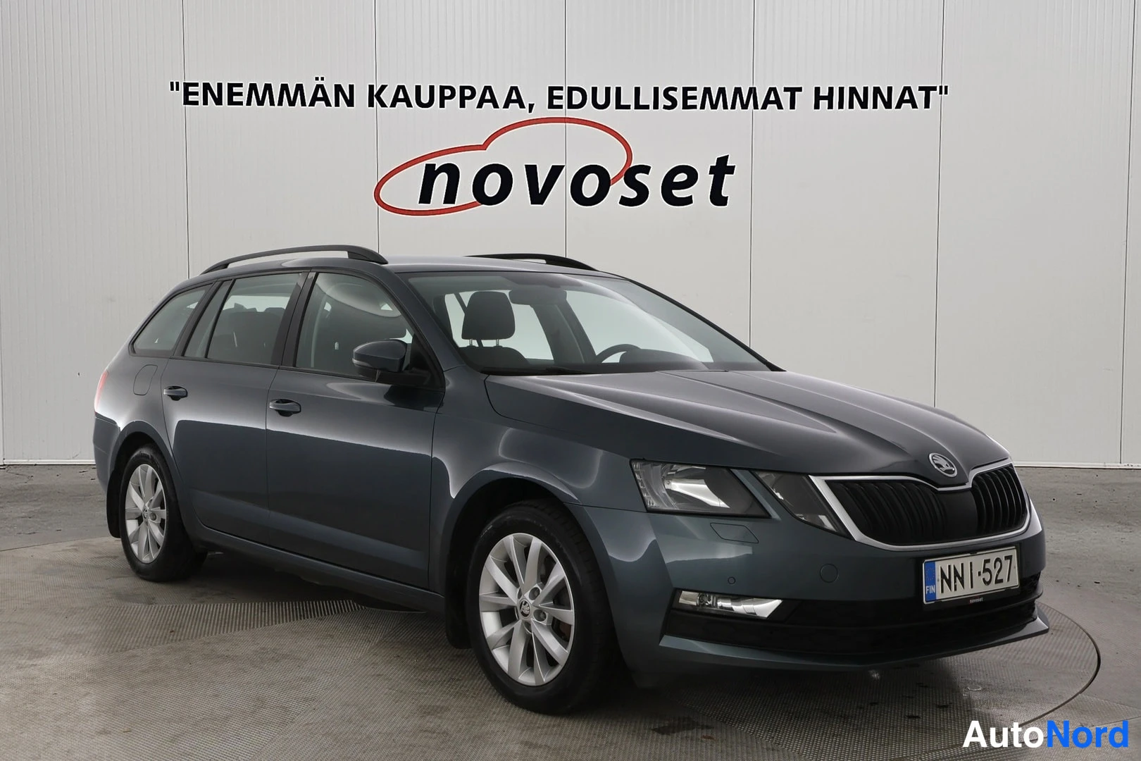 Etuviisto, nokka oikealle: Tummanharmaa Skoda Octavia -farmari kuvattu kolmesta neljänneksestä edestä oikealta, konepellin takana metallinhohtoinen konepelti ja tummat ulkopinnat h