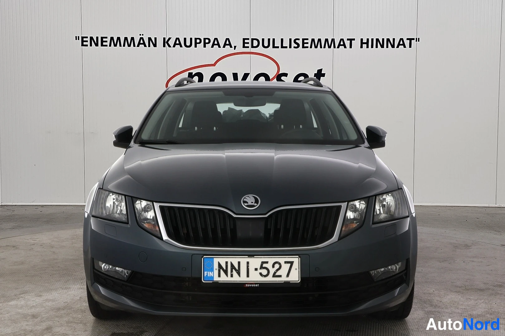Edestä: Skoda Octavian etupää suoraan edestä: tummanharmaa kori, etusäleikkö ja rekisterikilpi.