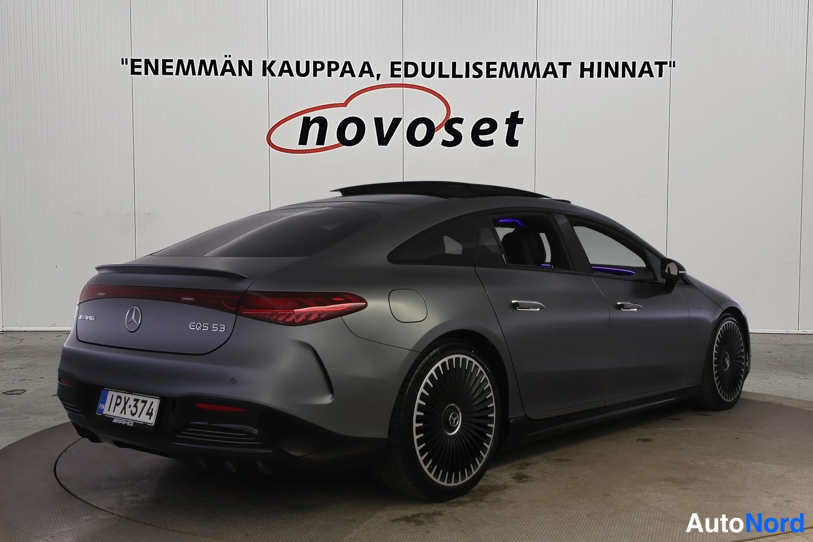 Takaviisto: Mercedes-Benzin takakulma vasemmalta, tummanharmaa sedan, EQS 53 -merkintä ja kilpi.