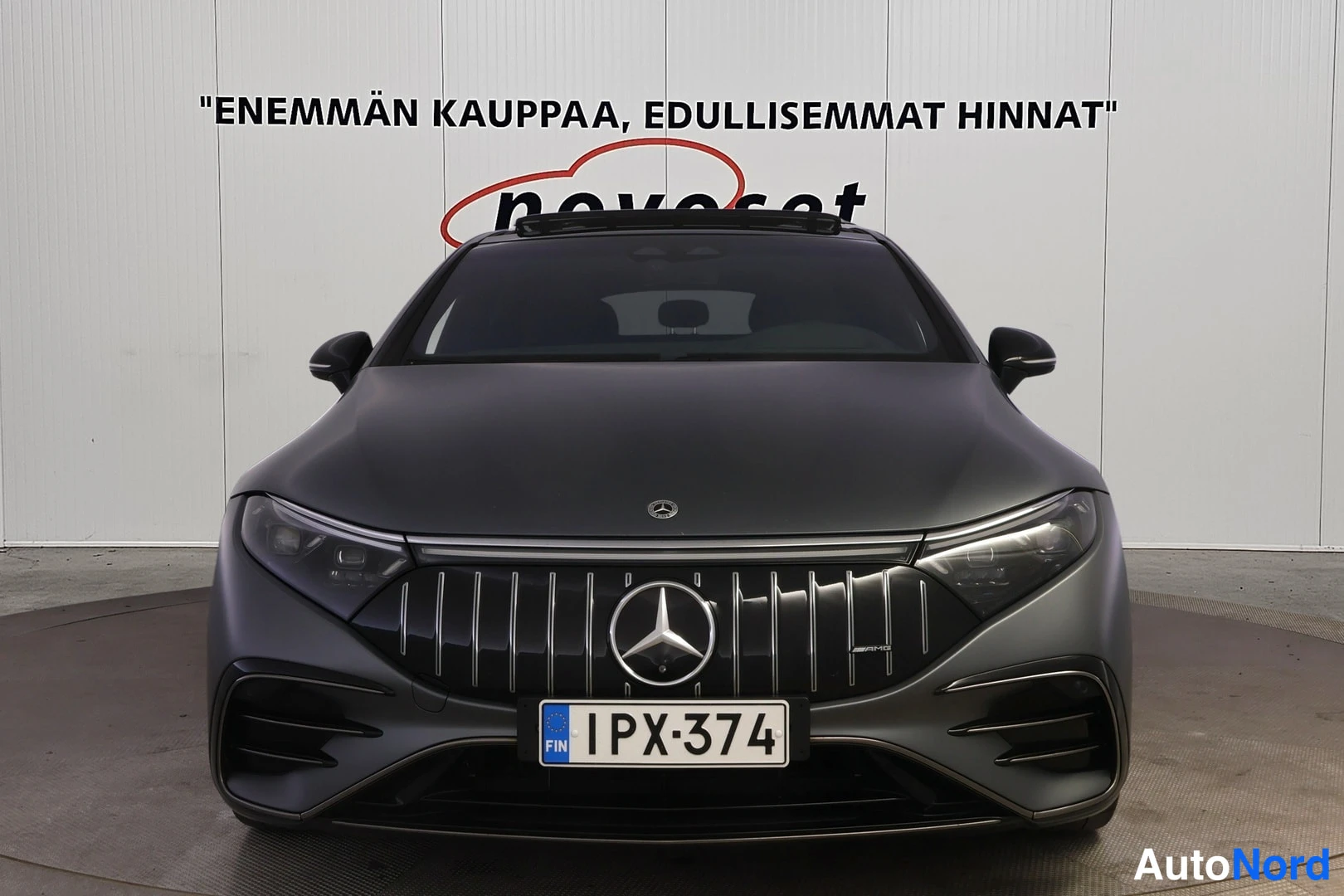 Edestä: Mercedes-Benzin suora etunäkymä, tummanharmaa kori, Mercedes-tähti keulassa, rekisterikilpi.