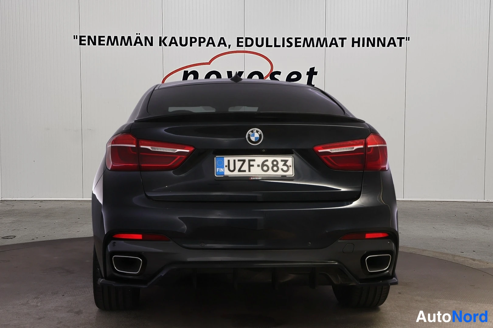 Takaa: Musta BMW X6 suoraan takaa, rekisteritunnus.