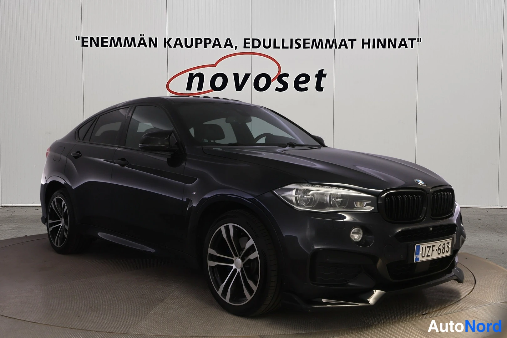 Etuviisto, nokka oikealle: Mustan värisen tilavautomobiilin etunäkymä vinosta oikealta; etusäleikkö, ajovalot ja rekisterikilpi näkyvät.