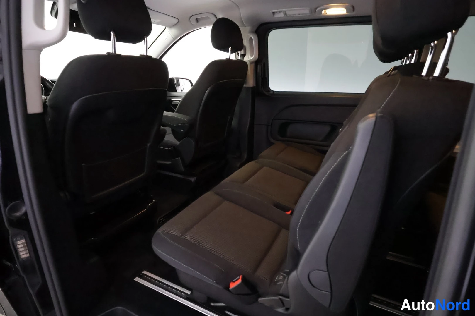 Muu: Mercedes-Benz V -tilavan merkin takapenkku ja irralliset istuimet tummassa kangasverhoilussa, kolu sisätiloista takaovi avattuna.