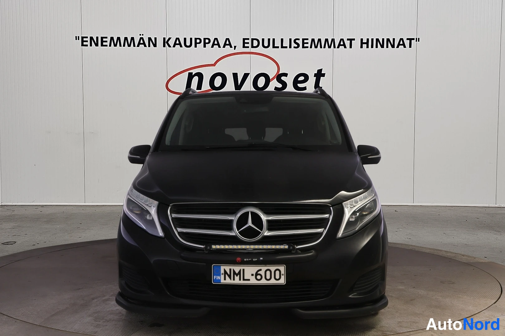 Edestä: Mustan Mercedes-Benz V -paketauton etunäkymä, etumaski ja ajovalot suoraan edestä.