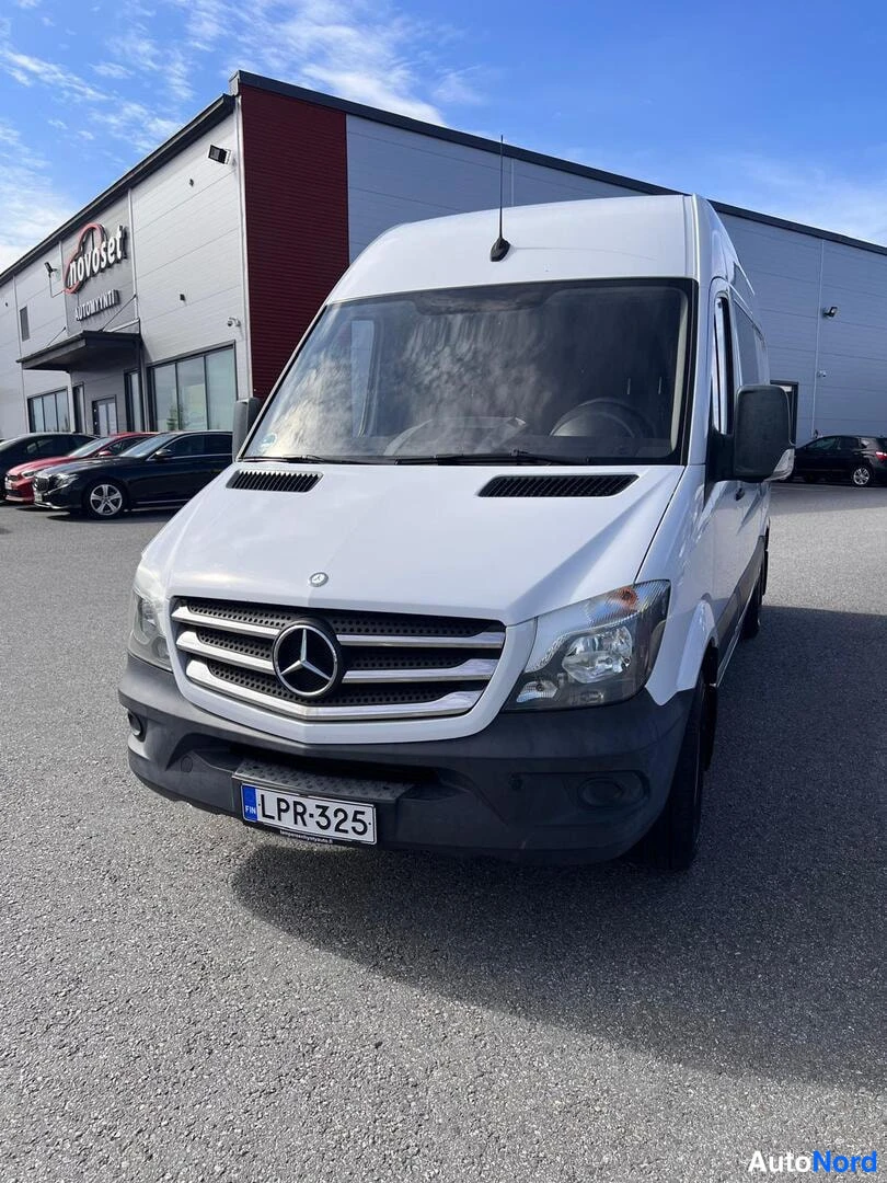 Edestä: Mercedes-Benz Sprinter -pakettiauto suoraan edestä kuvattuna, keulagridiaatti ja Mercedes-tähti, rekisterikilpi.